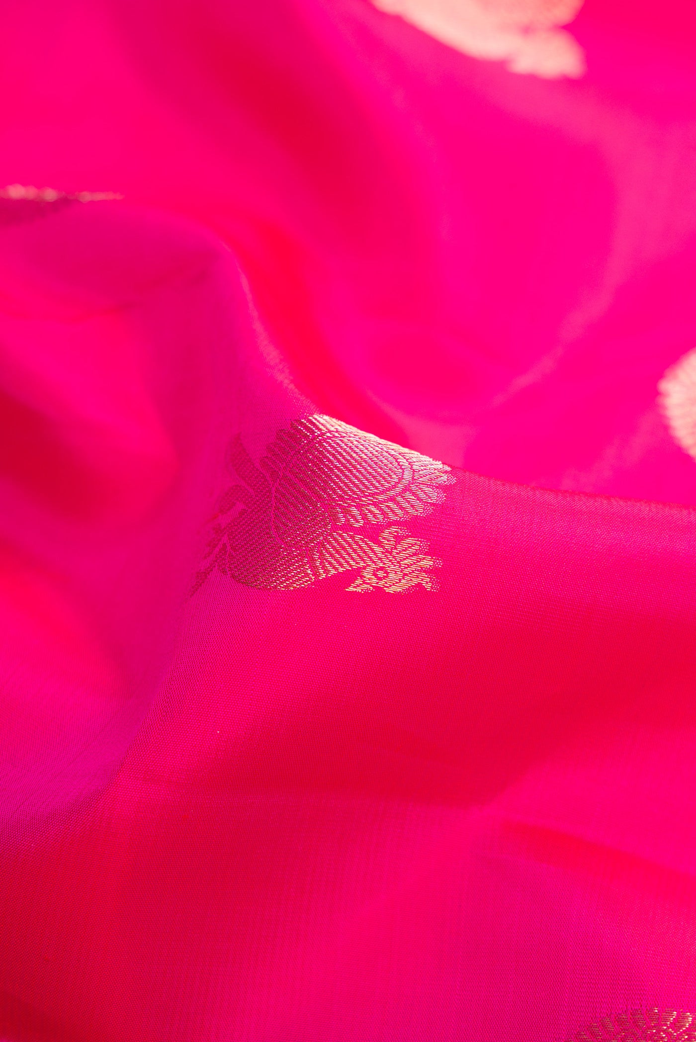 Close up of Pink Dual Tone Kanjivaram Silk Saree with Zari Butta on the body and Zari Border.  displaying folds