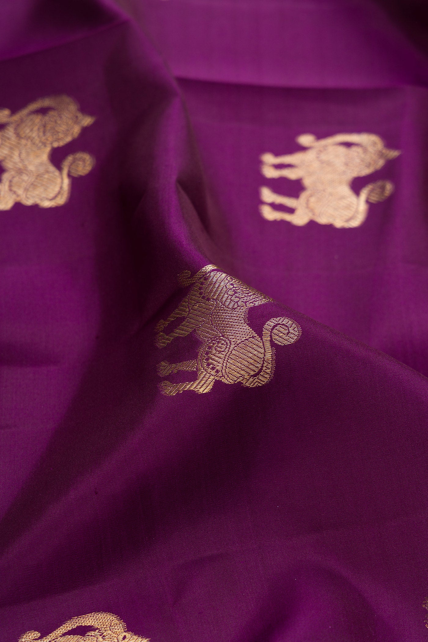 Close up of Purple Kanjivaram Silk Saree with Zari Butta on the body and Zari Border.  displaying folds