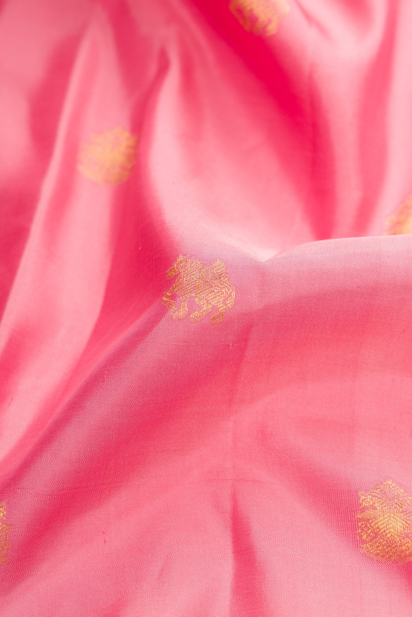 Close up of Pink Dual Tone Kanchipuram Silk Saree with Zari Butta on the body and Zari Border.  displaying folds
