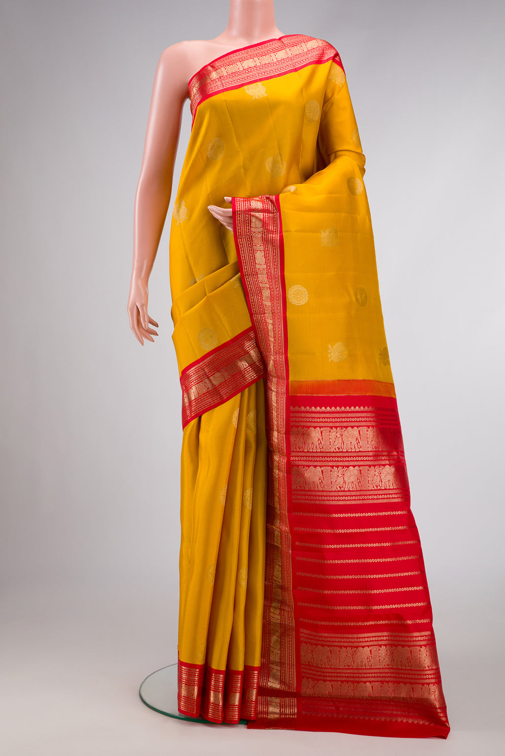 Yellow Dual Tone Kanchipuram Silk Saree with Zari Butta on the body and Zari Border.  displayed on a mannequin