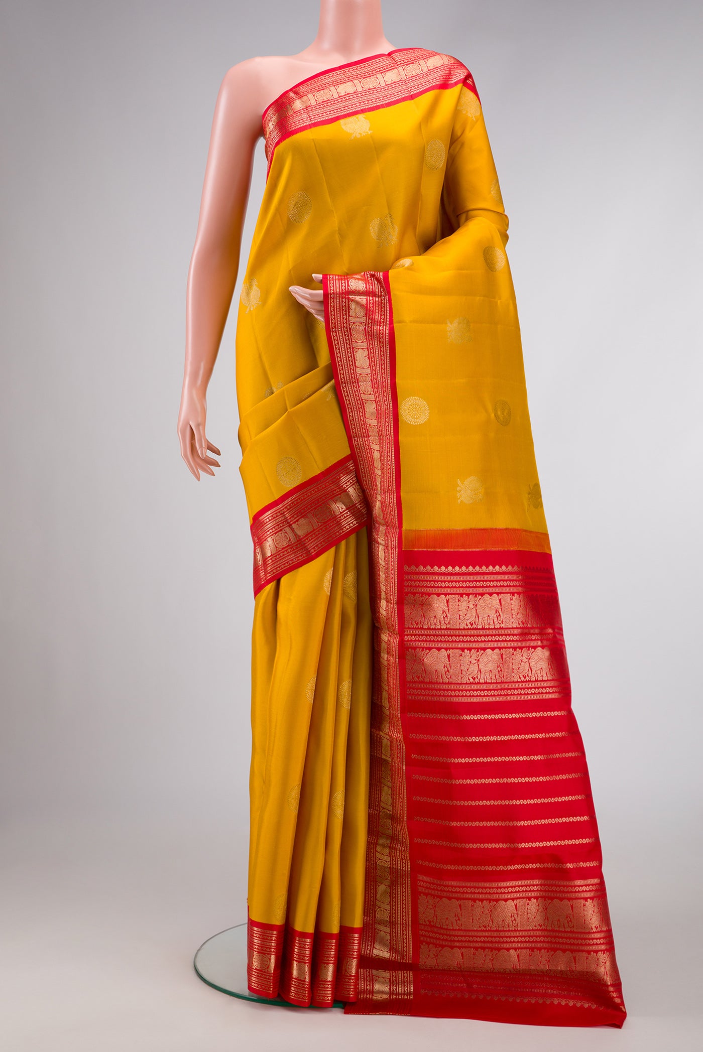Yellow Dual Tone Kanchipuram Silk Saree with Zari Butta on the body and Zari Border.  displayed on a mannequin