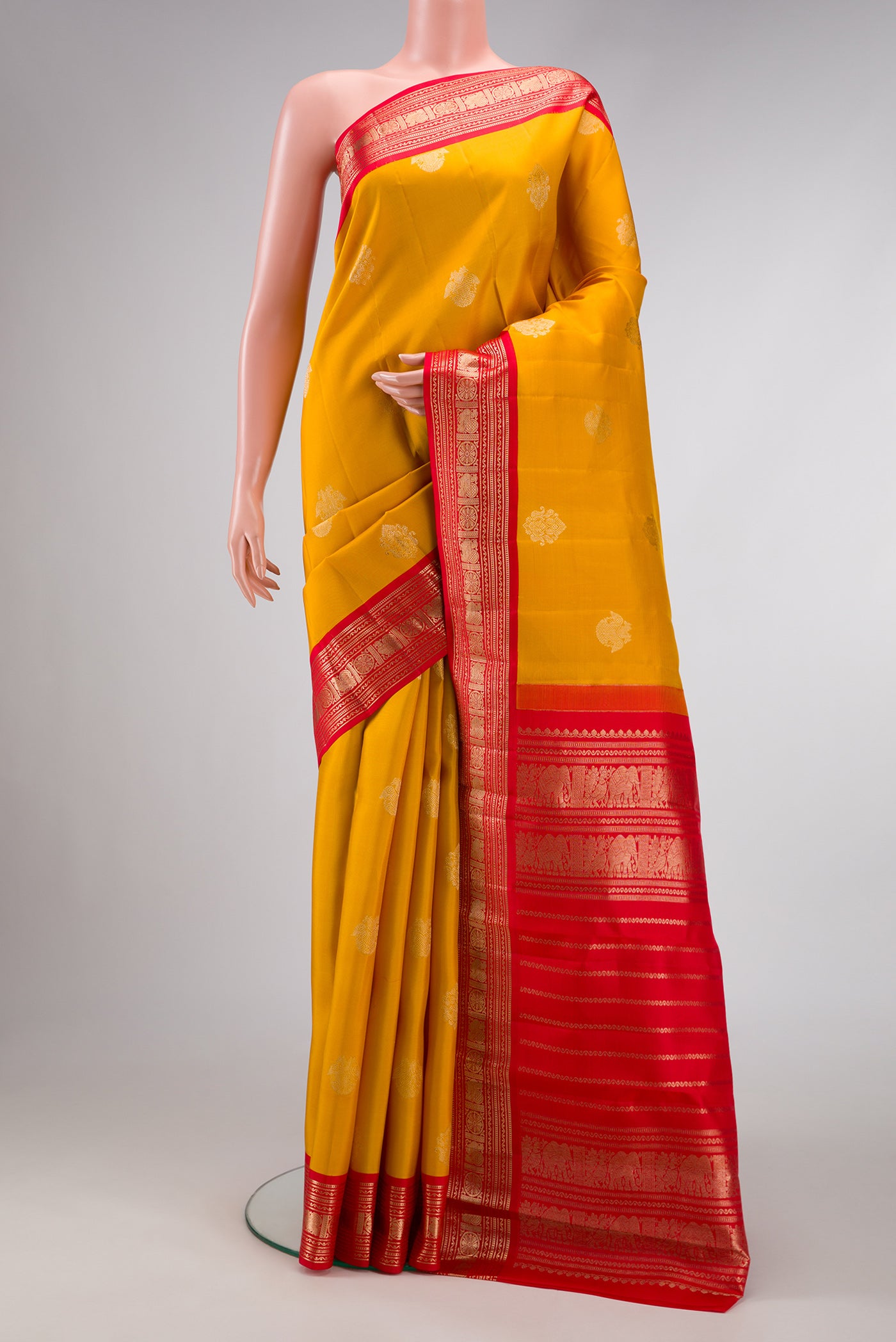 Yellow Dual Tone Kanchipuram Silk Saree with Zari Butta on the body and Zari Border.  displayed on a mannequin