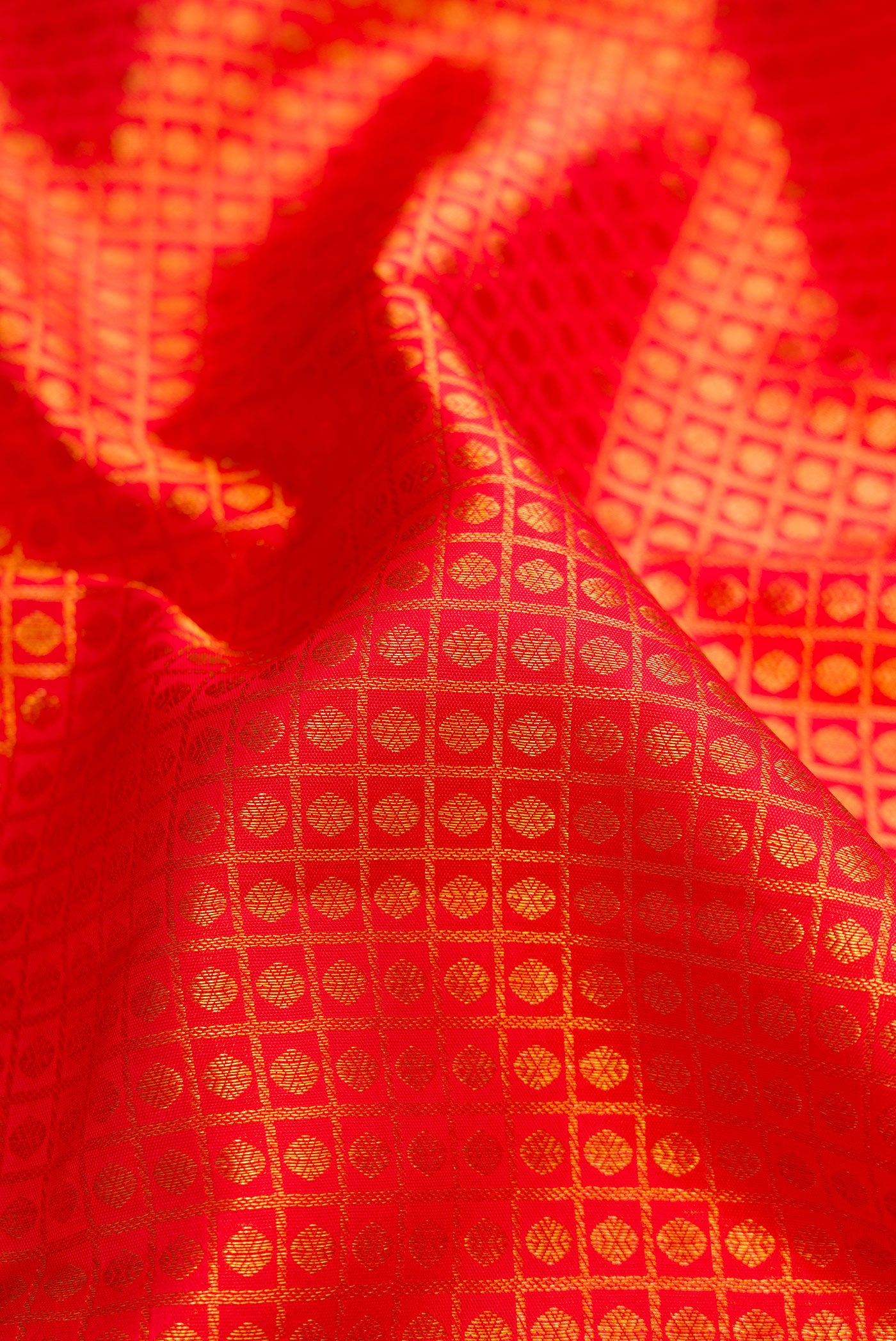 Close up of Red Dual Tone Kanchipuram Silk Saree with Zari Brocade on the body and Zari Border.  displaying folds