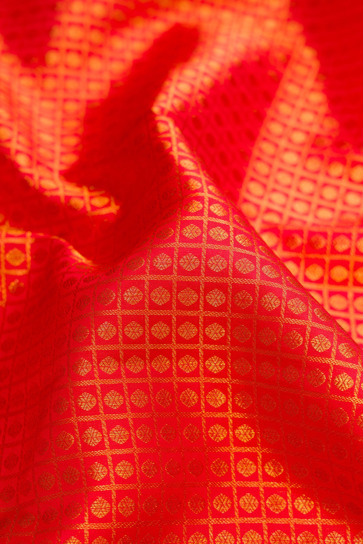 Close up of Red Dual Tone Kanchipuram Silk Saree with Zari Brocade on the body and Zari Border.  displaying folds