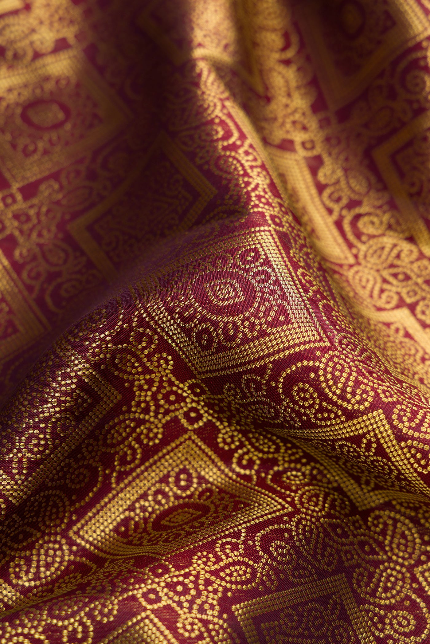 Close up of Maroon Dual Tone Kanchipuram Silk Saree with Zari Brocade on the body and Zari Border.  displaying folds