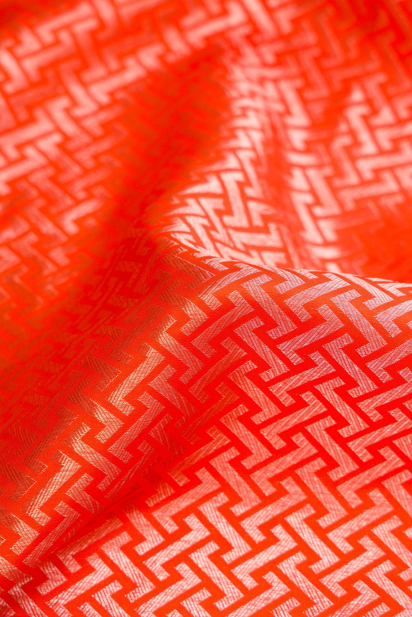 Close up of Orange Dual Tone Kanchipuram Silk Saree with Zari Brocade on the body and Zari Border.  displaying folds