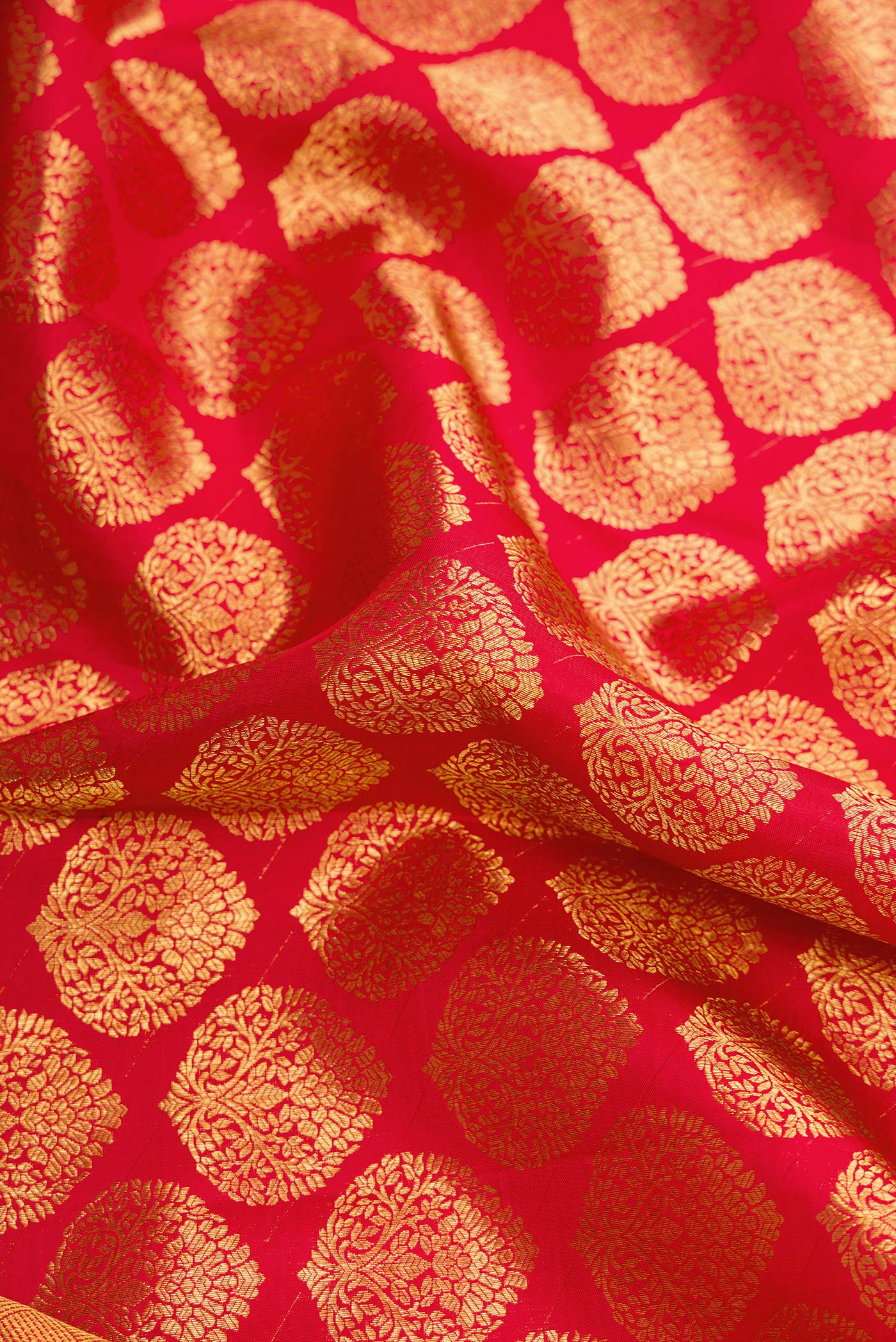 Close up of Red Dual Tone Kanchipuram Silk Saree with Zari Brocade on the body and Zari Border.  displaying folds
