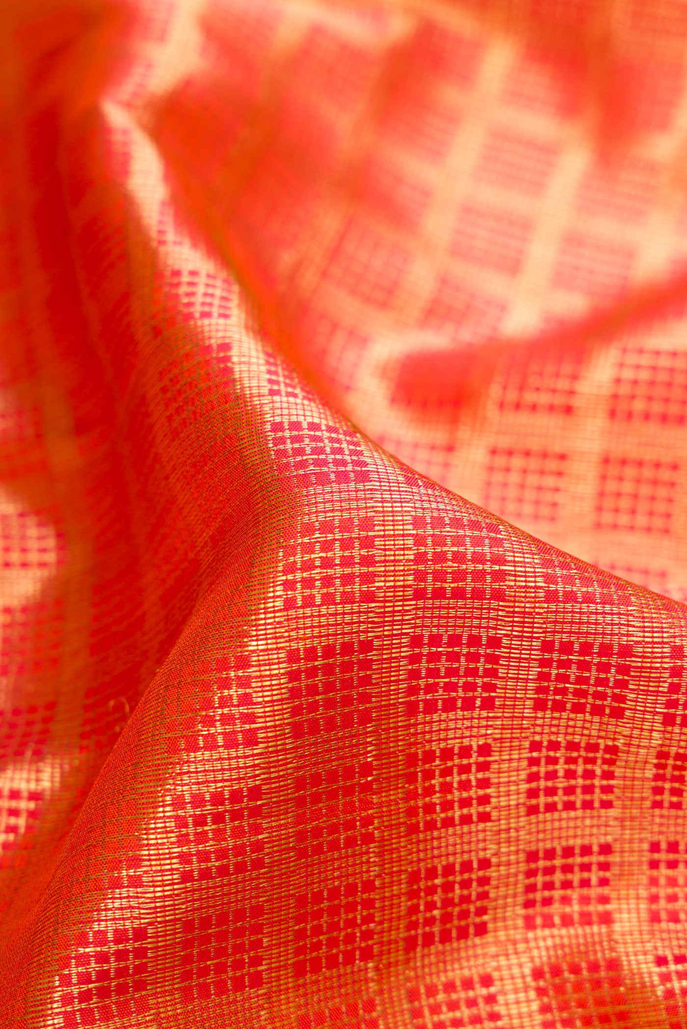 Close up of Orange Dual Tone Kanchipuram Silk Saree with Checked design on the body and Zari Border.  displaying folds