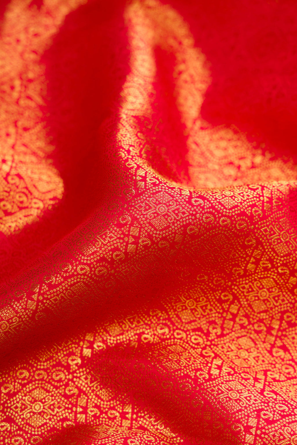 Close up of Red Dual Tone Kanchipuram Silk Saree with Zari Brocade on the body and Zari Border.  displaying folds