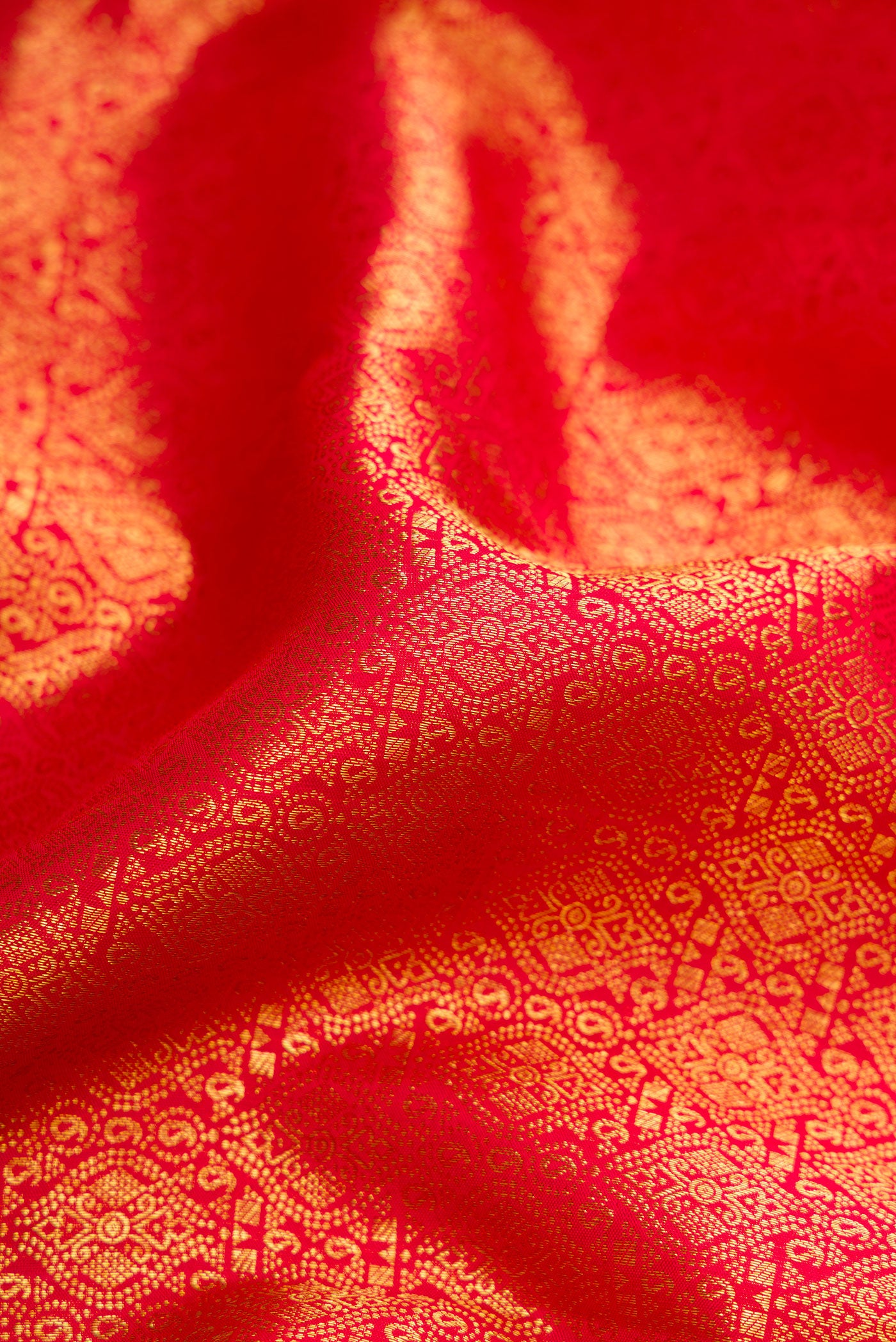 Close up of Red Dual Tone Kanchipuram Silk Saree with Zari Brocade on the body and Zari Border.  displaying folds