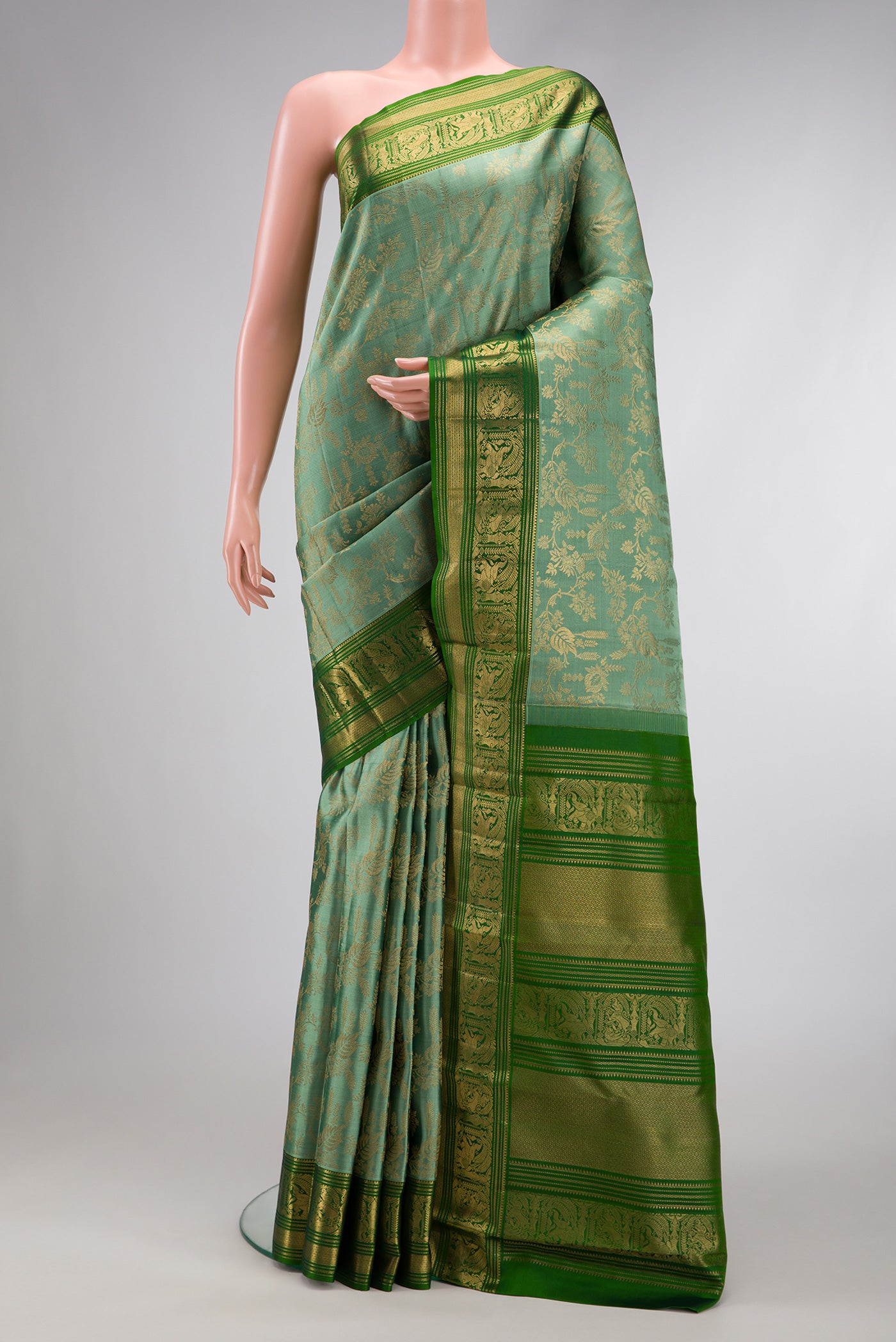 Mehandi Green Dual Tone Kanchipuram Silk Saree with Zari Brocade on the body and Zari Border.  displayed on a mannequin