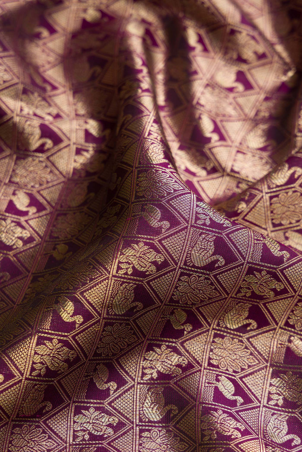 Close up of Magenta Dual Tone Kanchipuram Silk Saree with Zari Brocade on the body and Zari Border.  displaying folds