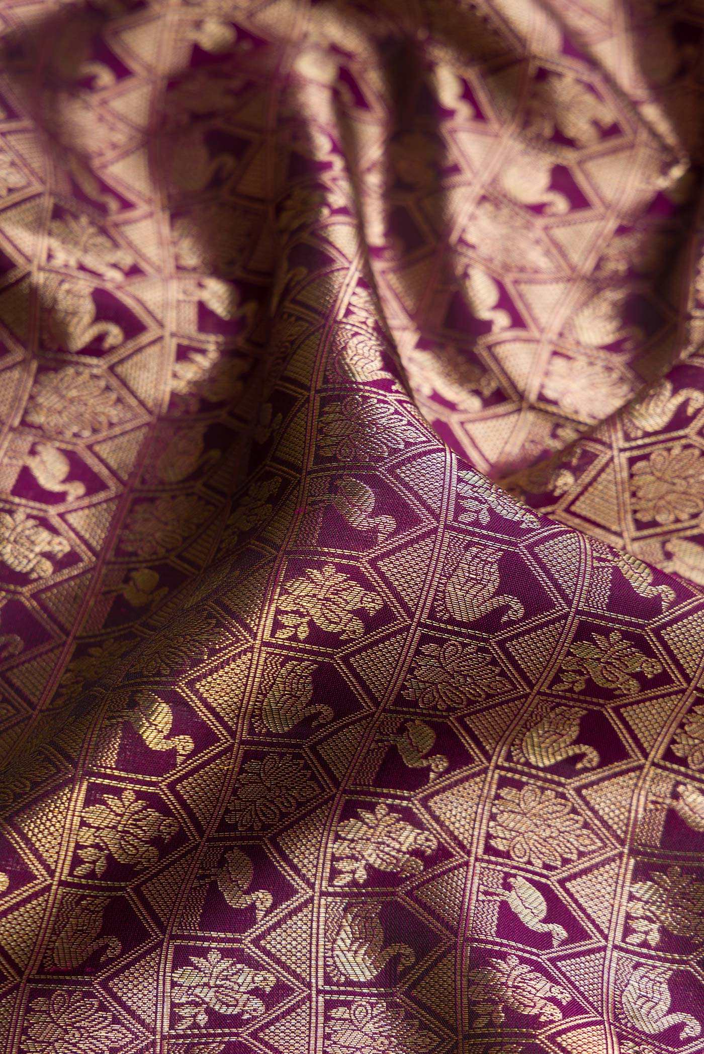 Close up of Magenta Dual Tone Kanchipuram Silk Saree with Zari Brocade on the body and Zari Border.  displaying folds