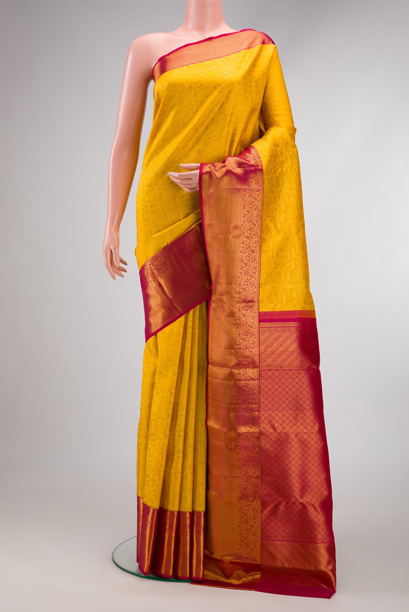 Yellow Kanchipuram Silk Saree with Zari Brocade on the body and Zari Border.  displayed on a mannequin