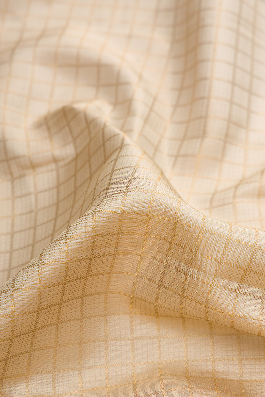 Close up of Beige Dual Tone Kanchipuram Silk Saree with Checked design on the body and Zari Border.  displaying folds