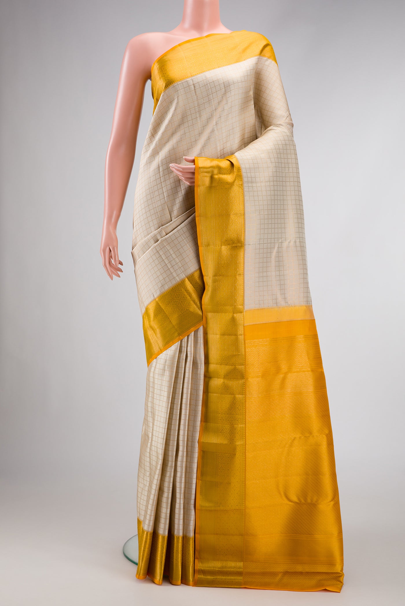 Beige Dual Tone Kanchipuram Silk Saree with Checked design on the body and Zari Border.  displayed on a mannequin