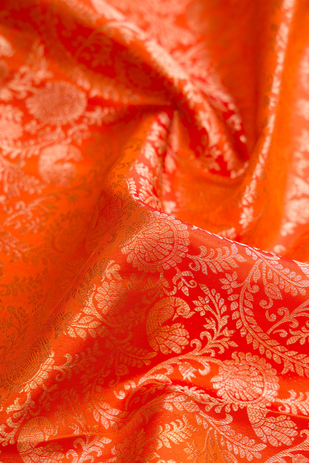 Close up of Orange Dual Tone Kanchipuram Silk Saree with Zari Brocade on the body and Zari Border.  displaying folds
