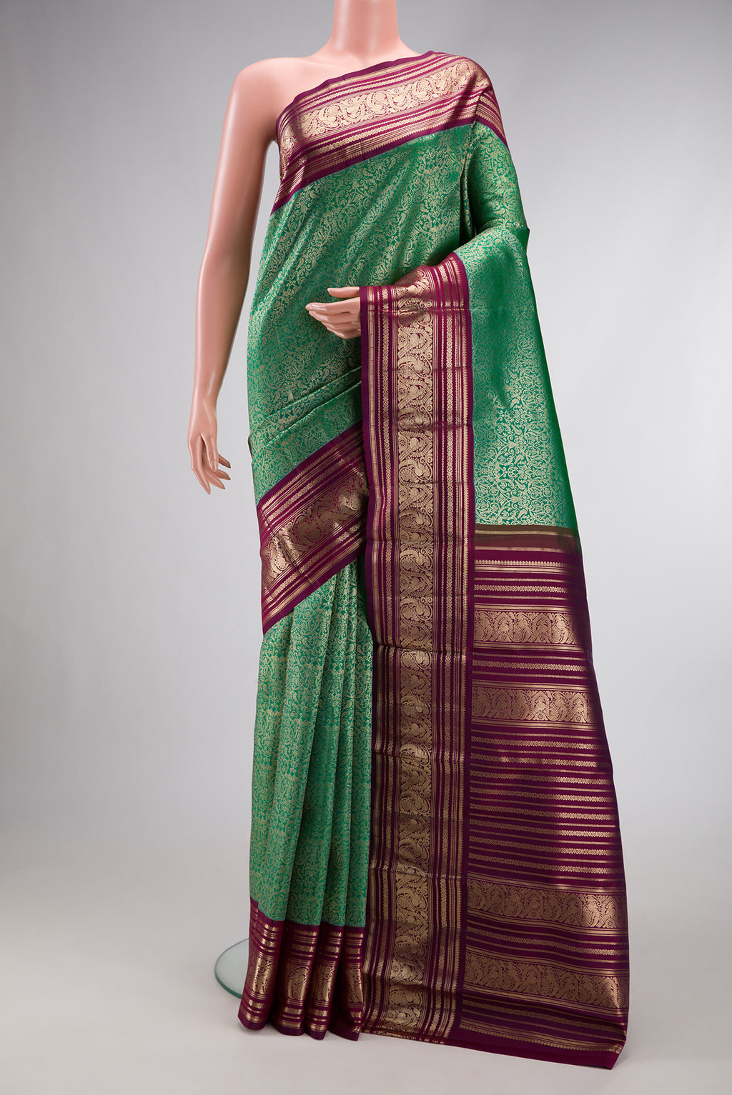 Sea Green Dual Tone Kanchipuram Silk Saree with Zari Brocade on the body and Zari Border.  displayed on a mannequin