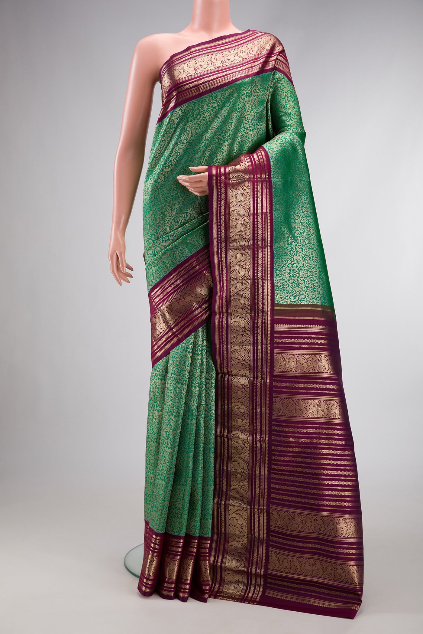 Sea Green Dual Tone Kanchipuram Silk Saree with Zari Brocade on the body and Zari Border.  displayed on a mannequin