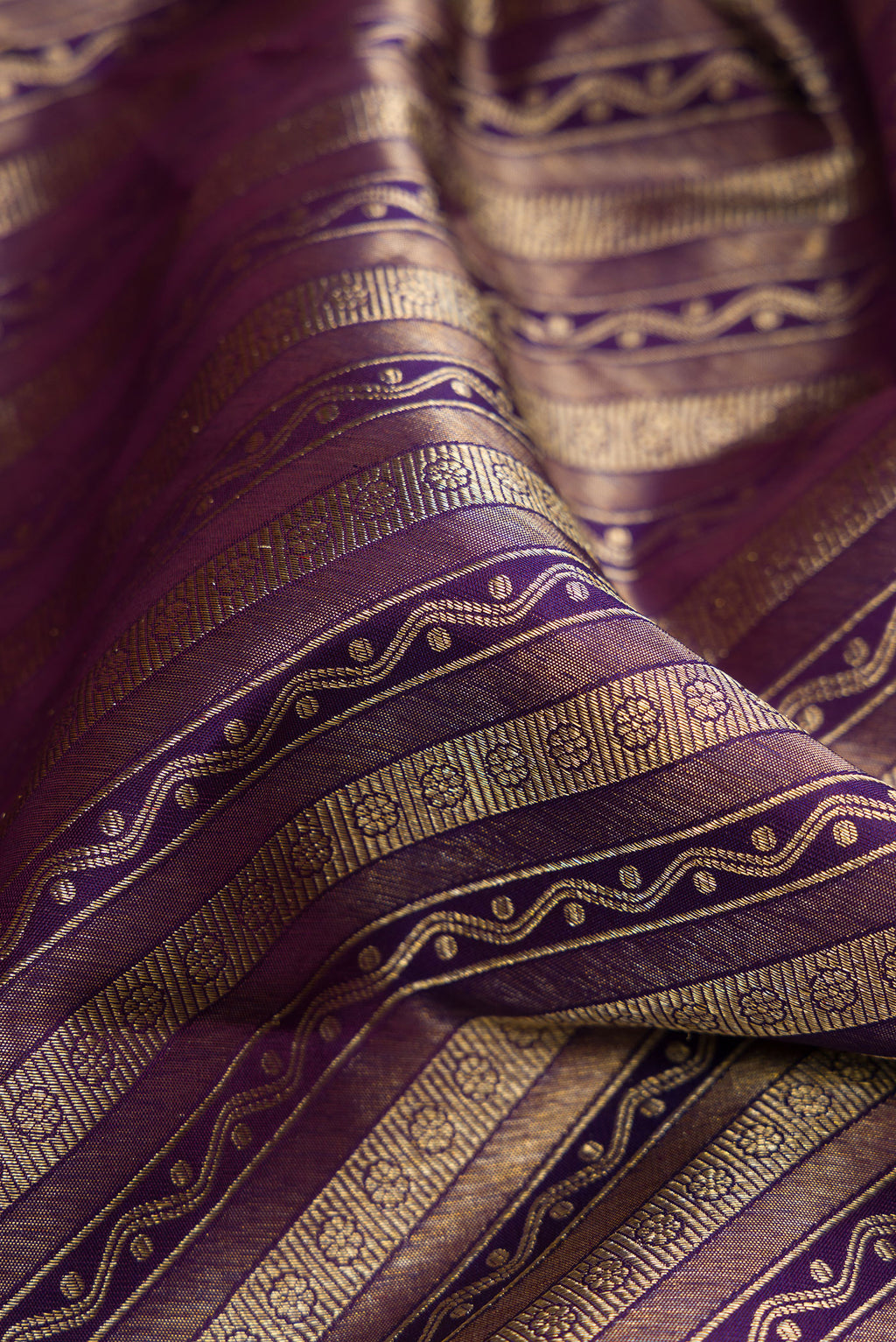 Close up of Purple Dual Tone Kanchipuram Silk Saree with Zari Brocade on the body and Zari Border.  displaying folds