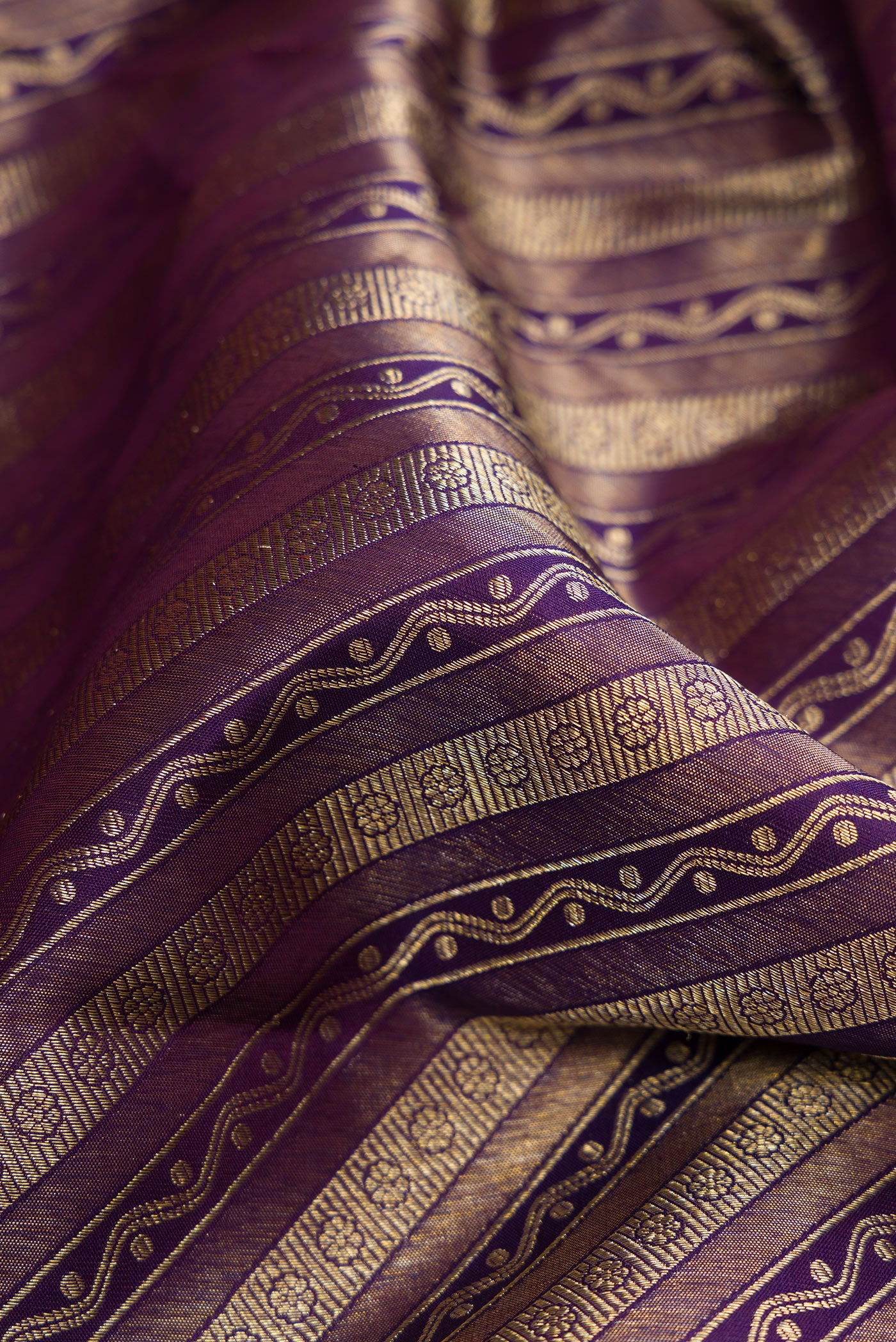 Close up of Purple Dual Tone Kanchipuram Silk Saree with Zari Brocade on the body and Zari Border.  displaying folds