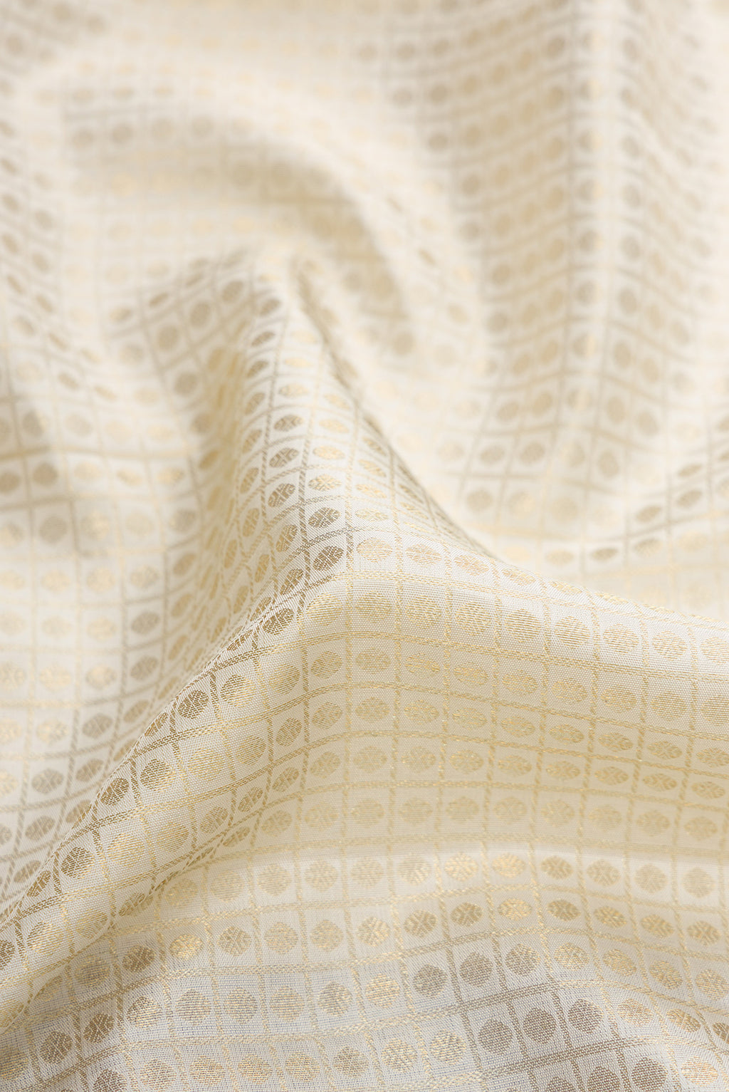 Close up of Off White Dual Tone Kanchipuram Silk Saree with Zari Brocade on the body and Zari Border.  displaying folds