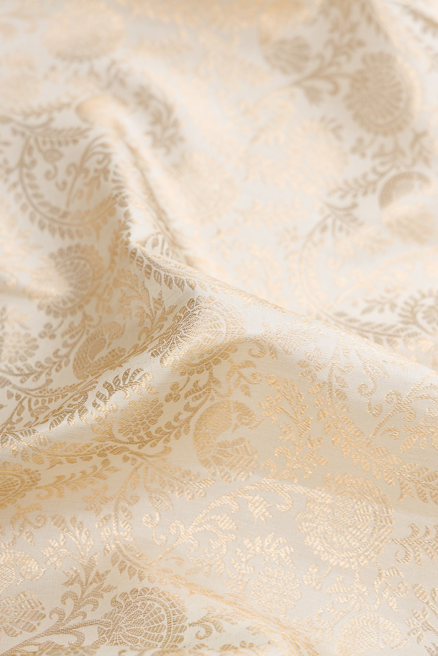 Close up of Off White Dual Tone Kanchipuram Silk Saree with Zari Brocade on the body and Zari Border.  displaying folds