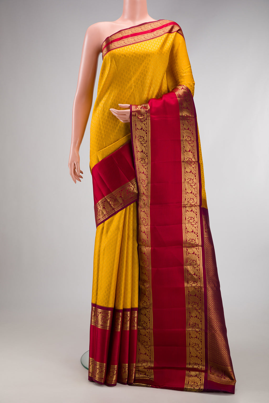 Yellow Kanchipuram Silk Saree with Zari Brocade on the body and Zari Border.  displayed on a mannequin