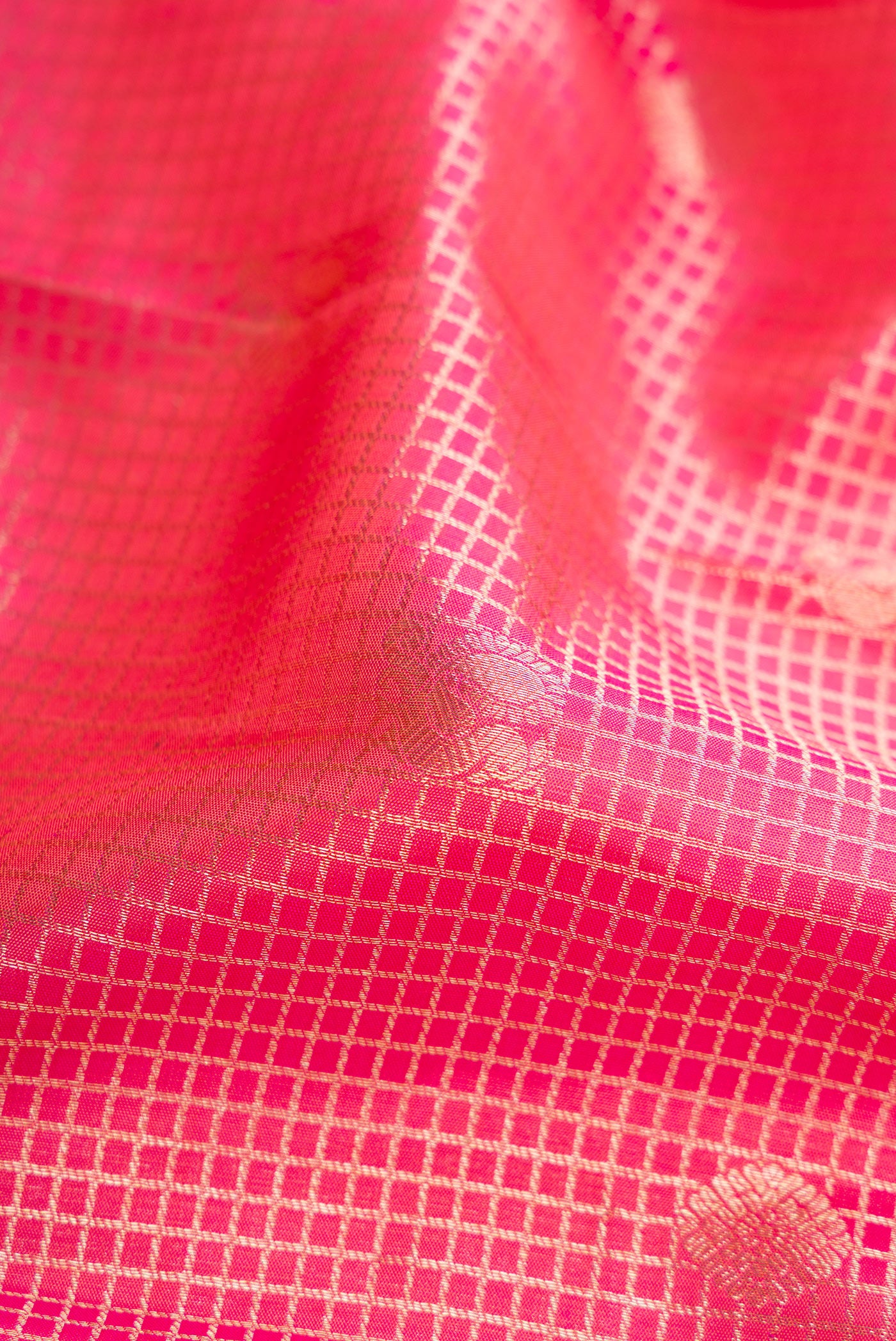 Close up of Pink Dual Tone Kanchipuram Silk Saree with Checked design on the body and Zari Border.  displaying folds