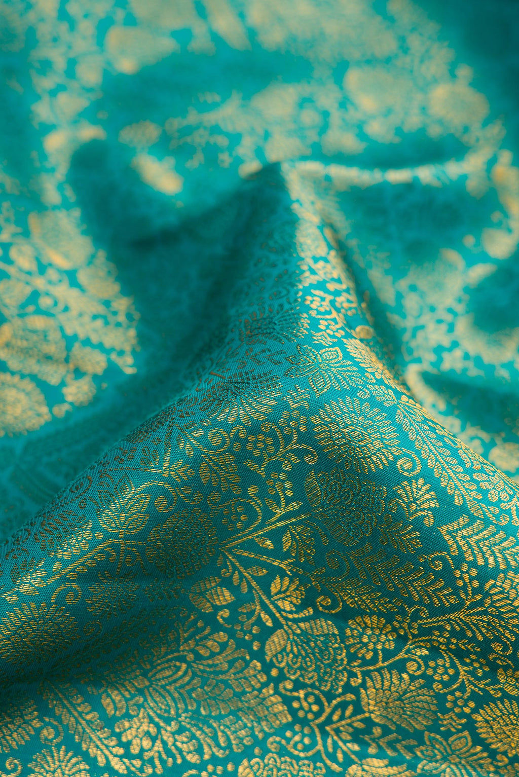 Close up of Peacock Blue Dual Tone Kanchipuram Silk Saree with Zari Brocade on the body and Zari Border.  displaying folds