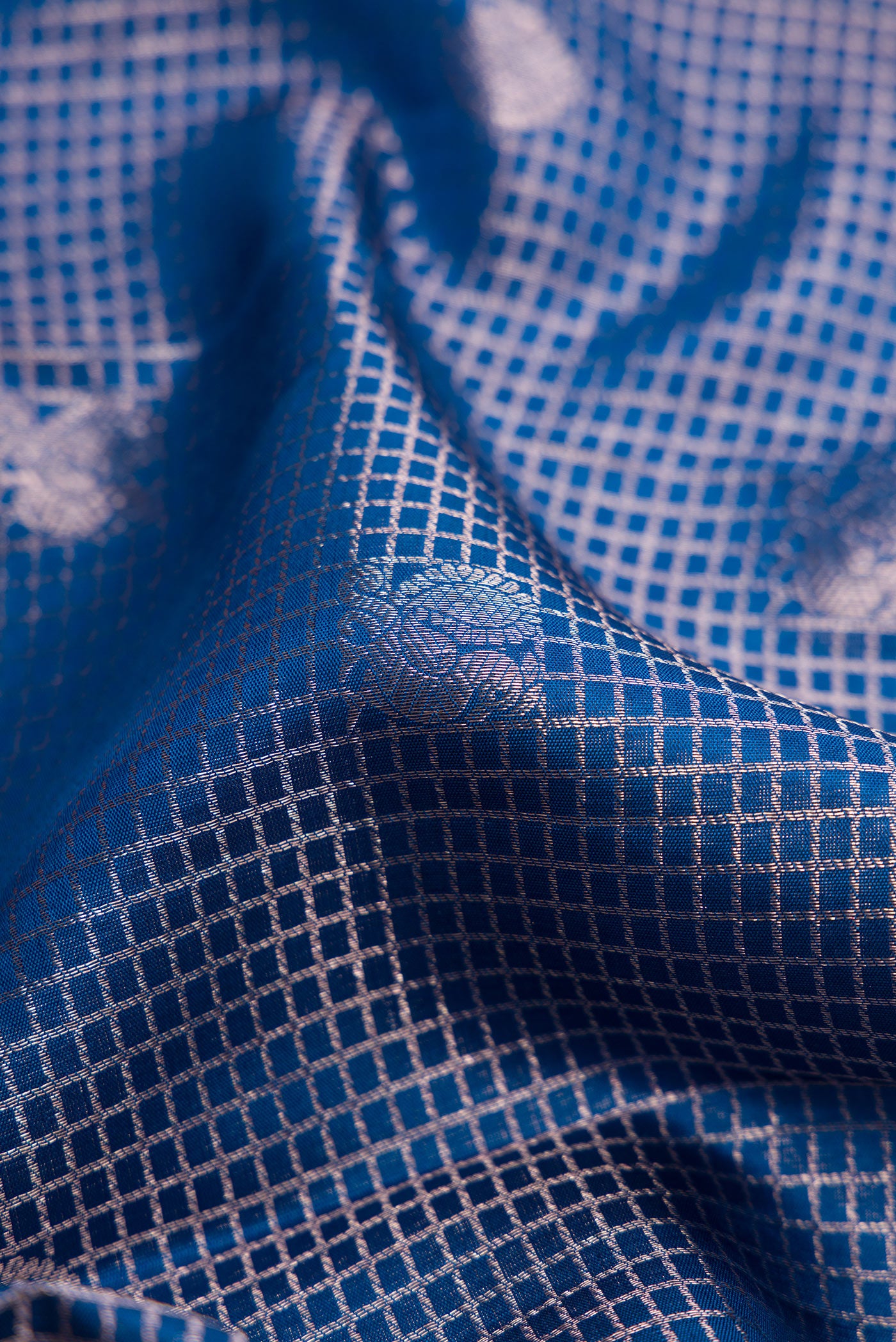 Close up of Peacock Blue Dual Tone Kanchipuram Silk Saree with Zari Brocade on the body and Zari Border.  displaying folds