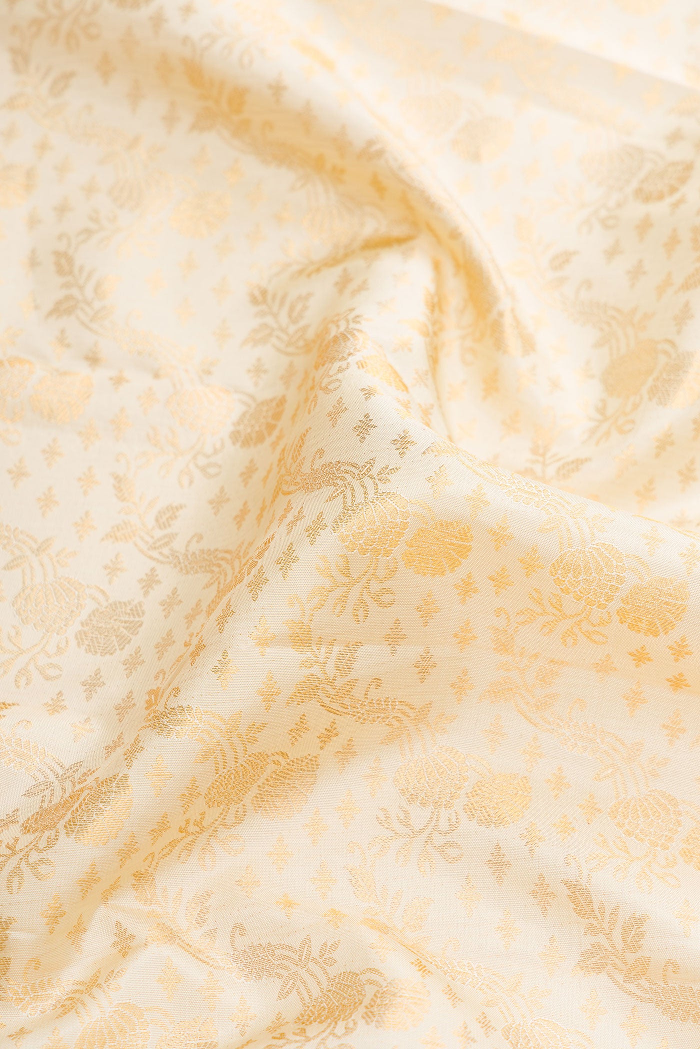 Close up of Off White Dual Tone Kanjivaram Silk Saree with Zari Brocade on the body and Zari Border.  displaying folds