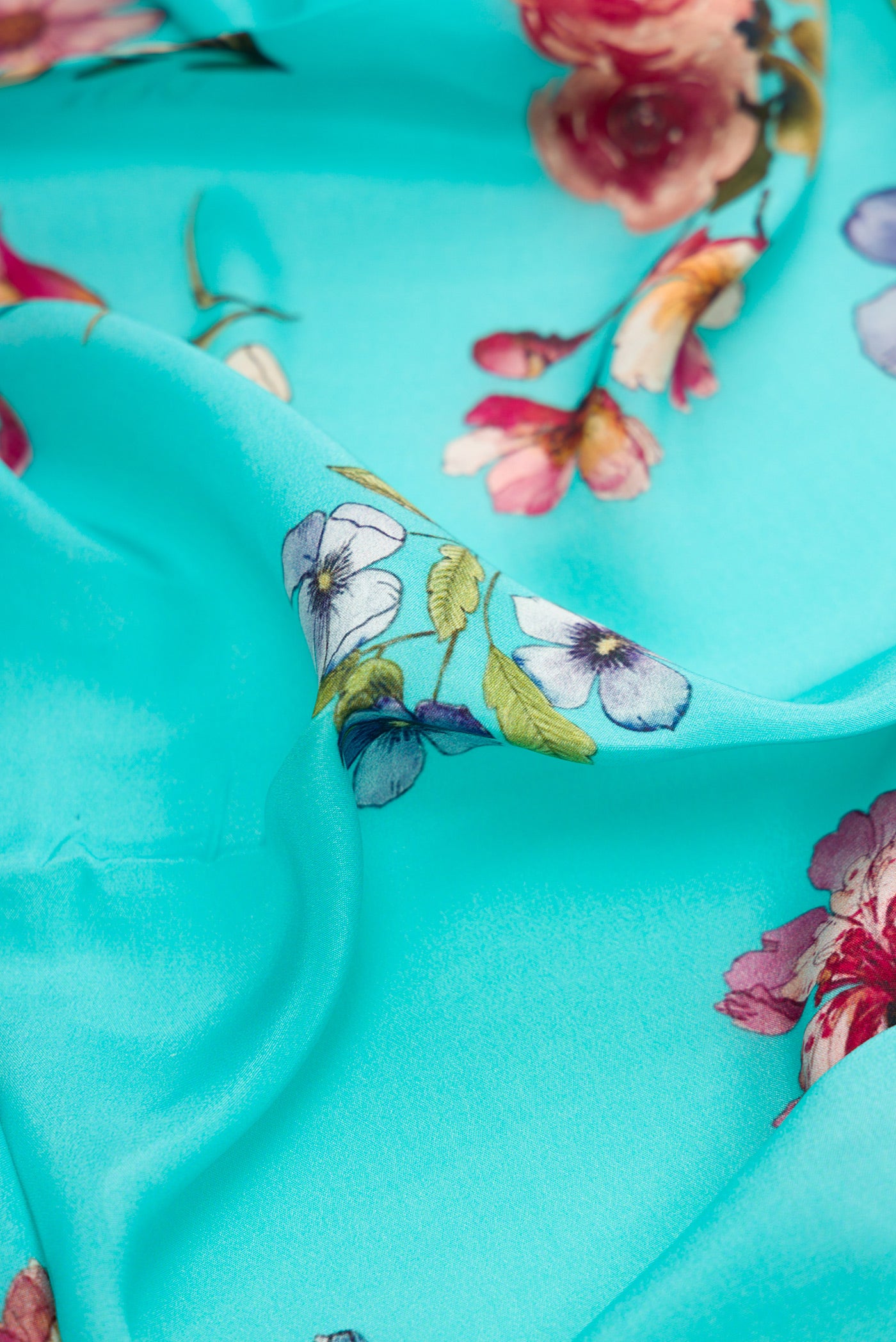 Close up of Sky Blue Dual Tone Mysore Crepe Saree with Printed design on the body and Without Border.  displaying folds