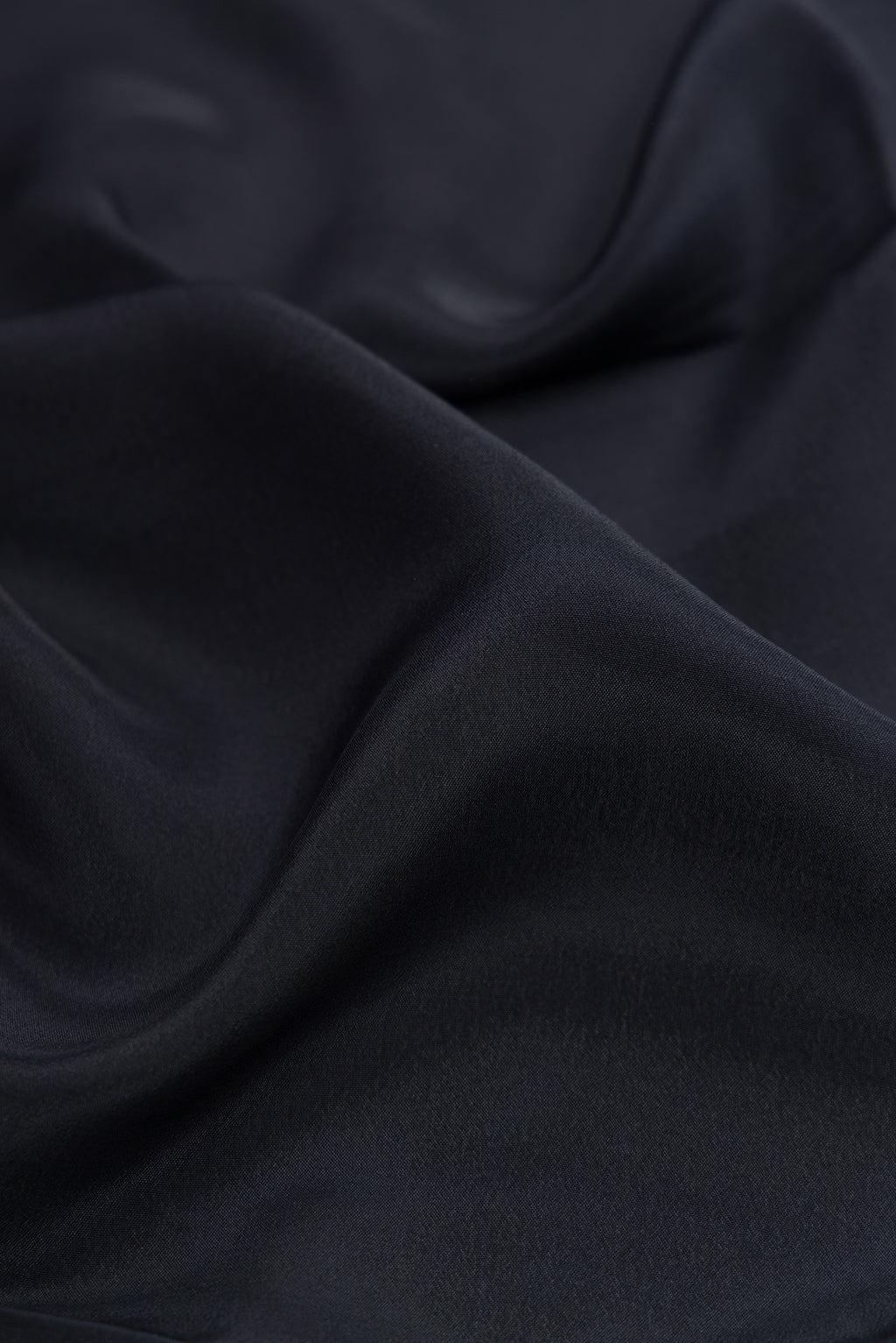 Close up of Black Crepe Saree with Plain Body and Printed Border.  displaying folds