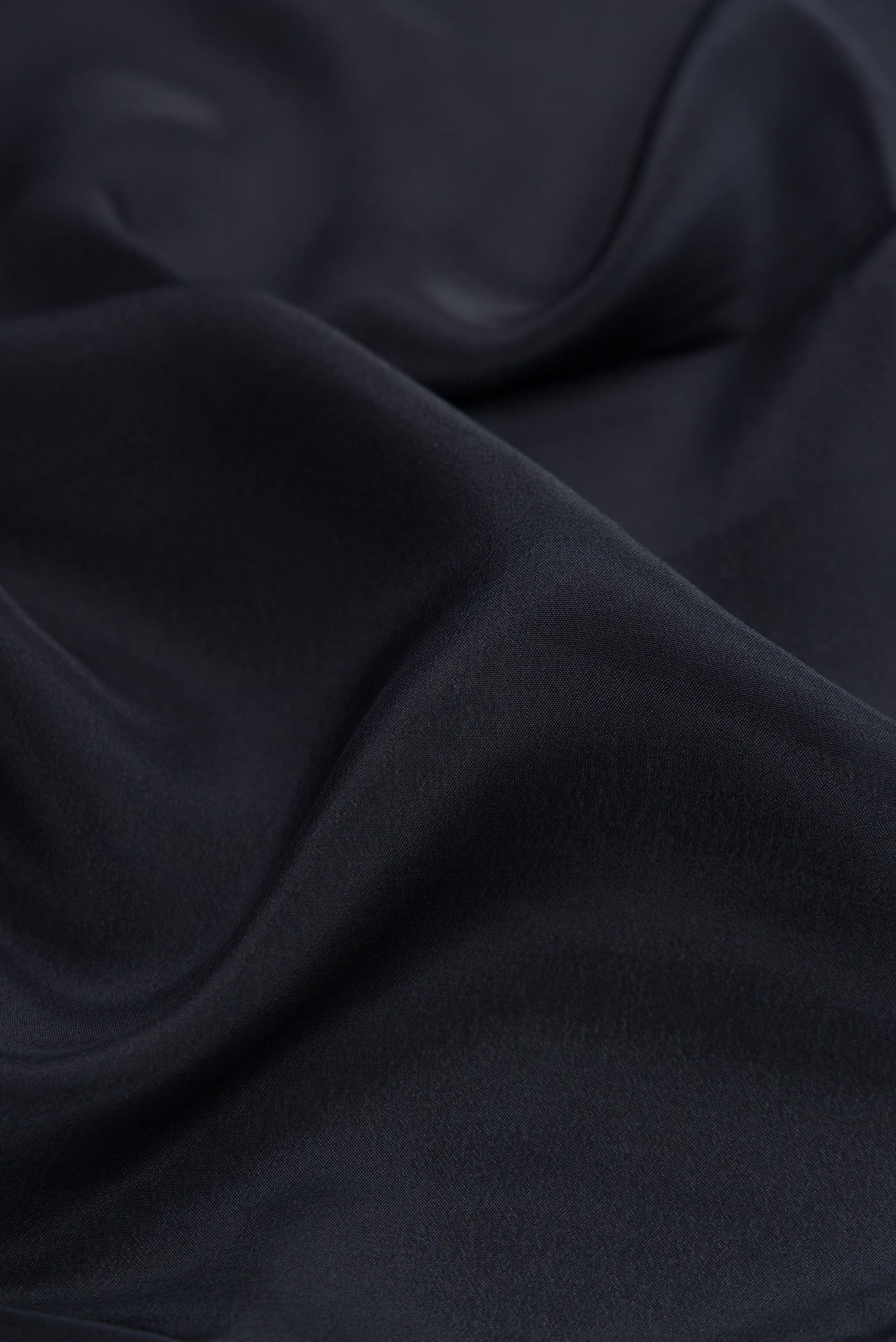Close up of Black Crepe Saree with Plain Body and Printed Border.  displaying folds