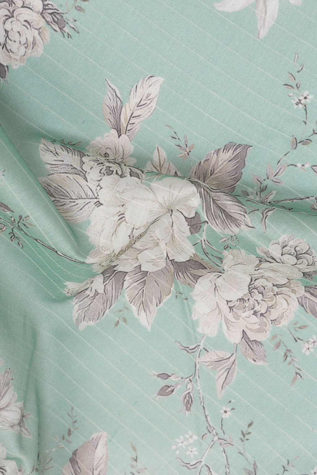 Close up of Pure Silk Sea Green Dual Tone Chanderi Saree with Printed design on the body and Zari Border.  displaying folds