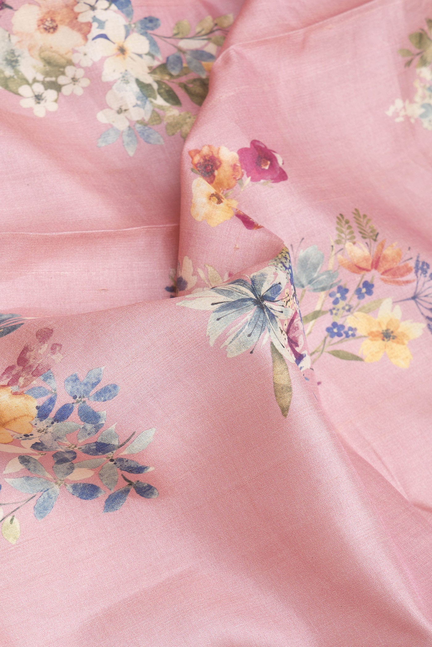 Close up of Pink Tussar Silk Saree with Floral Print on the body and Zari Border.  displaying folds