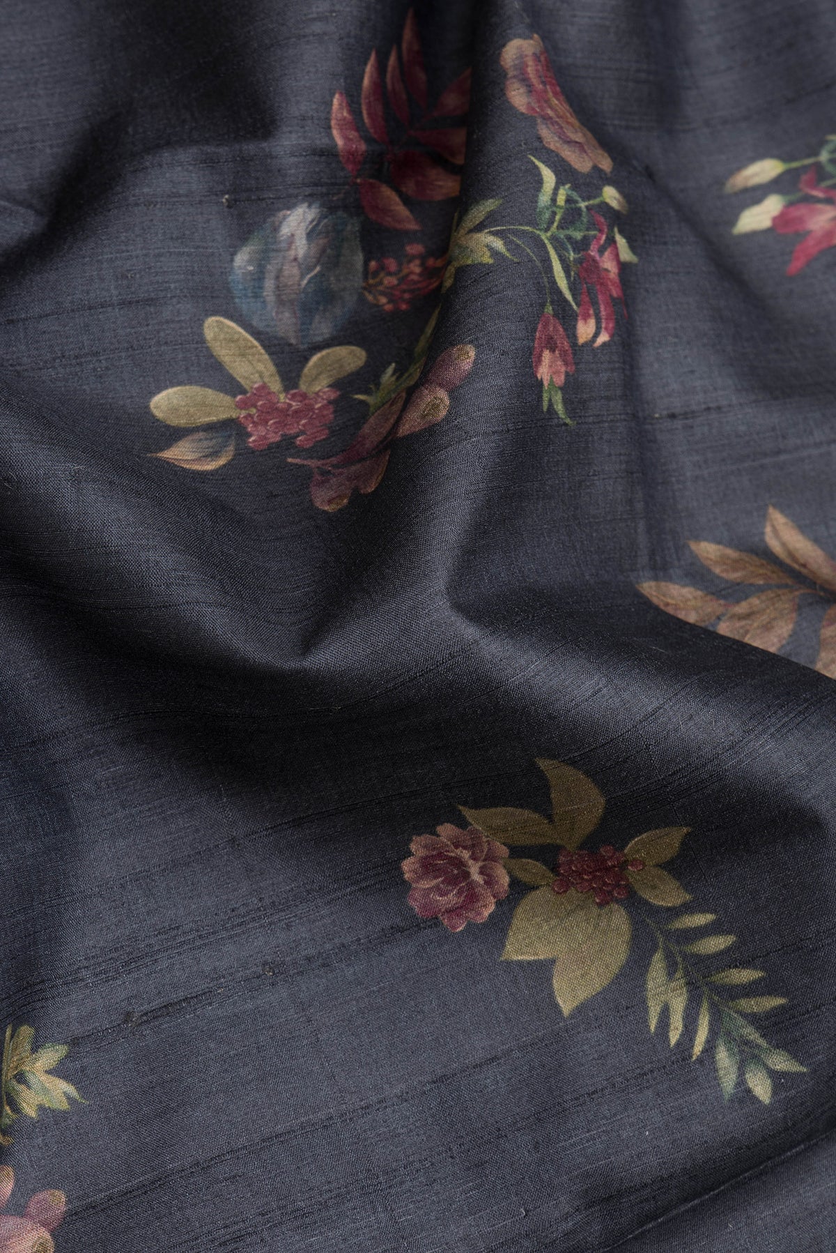 Close up of Black Dual Tone Tussar Silk Saree with Printed design on the body and Zari Border.  displaying folds
