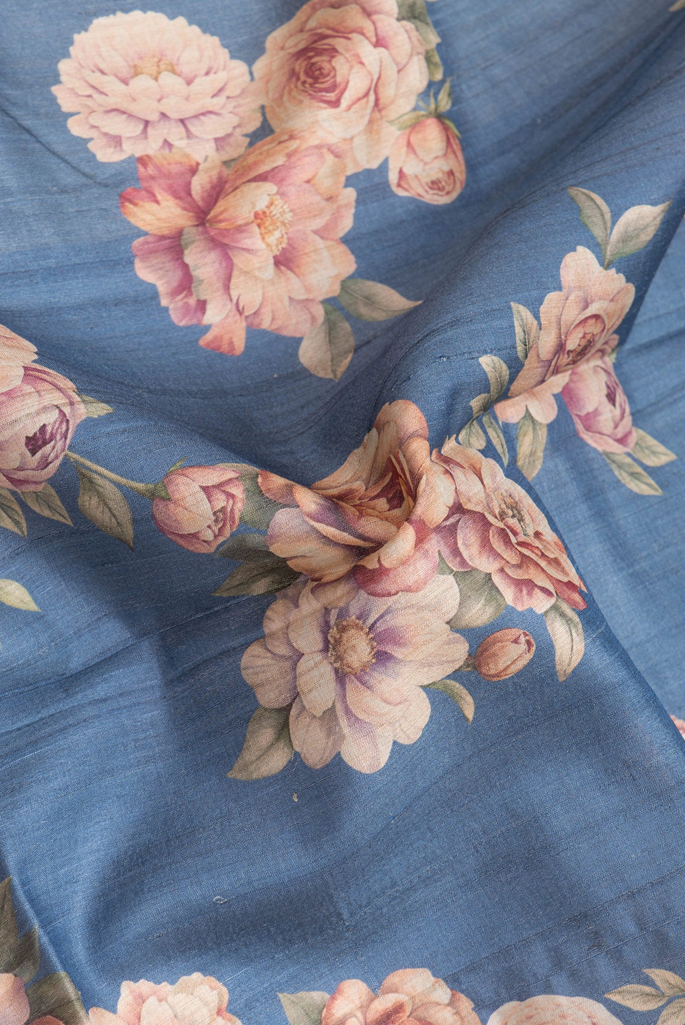 Close up of Blue Dual Tone Tussar Silk Saree with Printed design on the body and Zari Border.  displaying folds