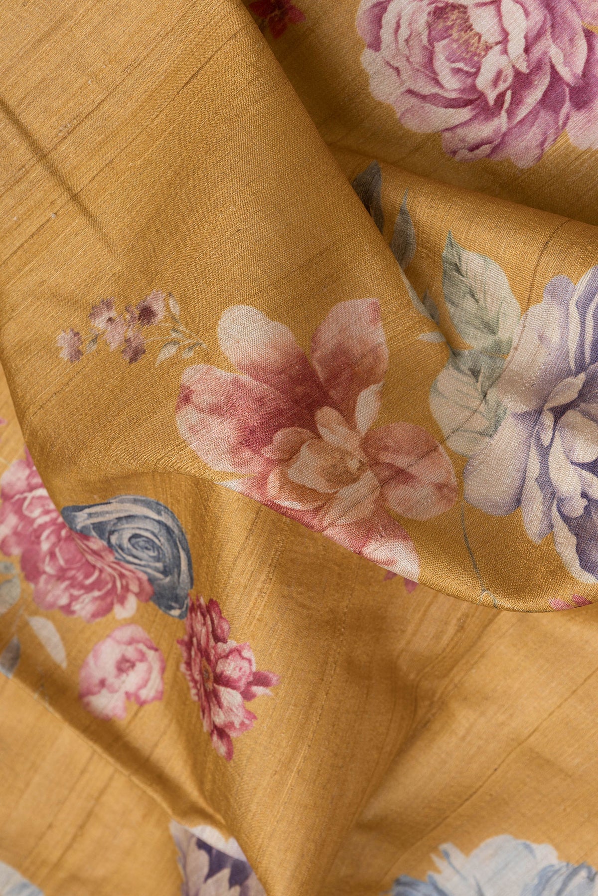 Close up of Mustard Dual Tone Tussar Silk Saree with Printed design on the body and Zari Border.  displaying folds