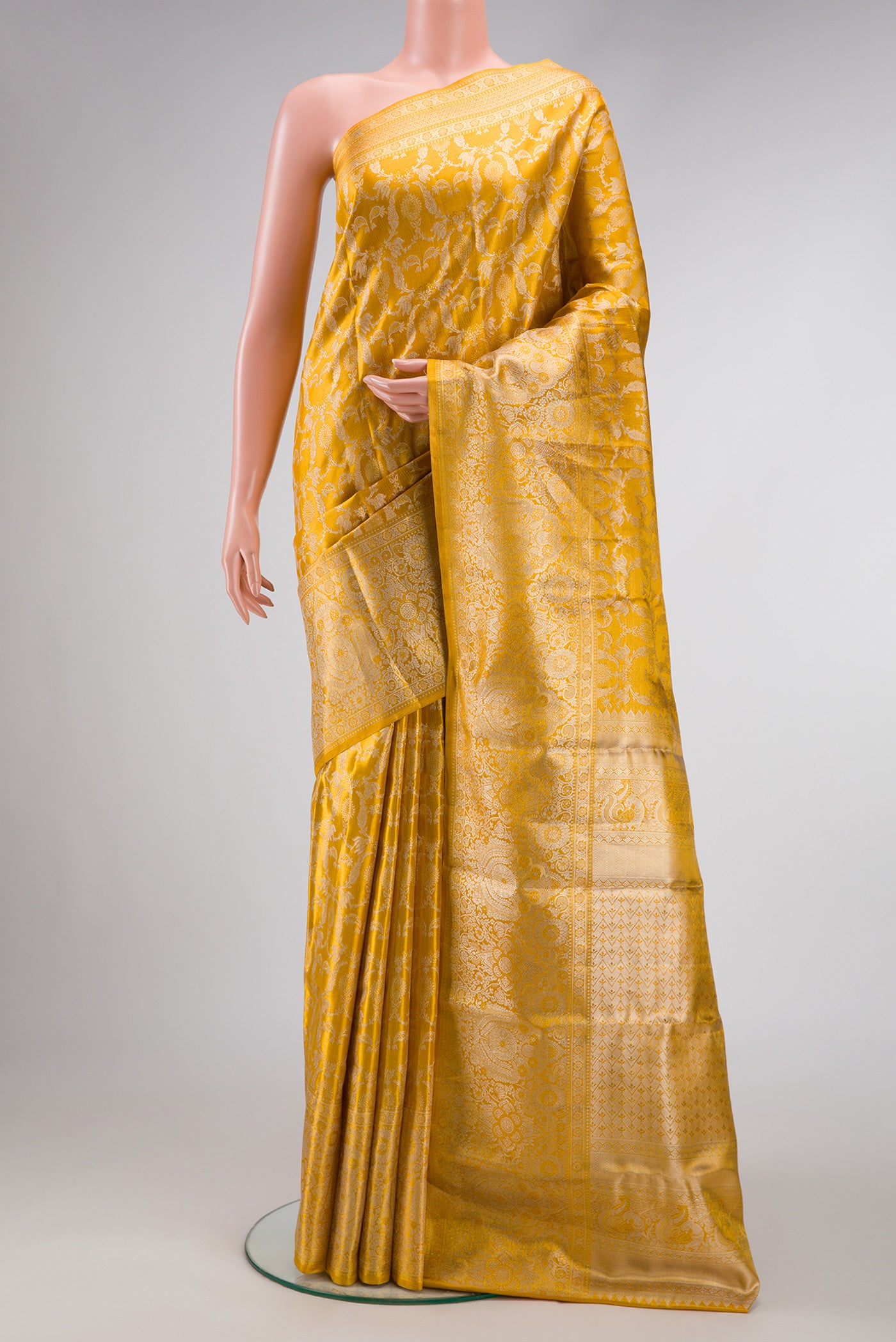 Gold Dual Tone Kanjivaram Tissue Silk Saree with Zari Brocade on the body and Zari Border.  displayed on a mannequin