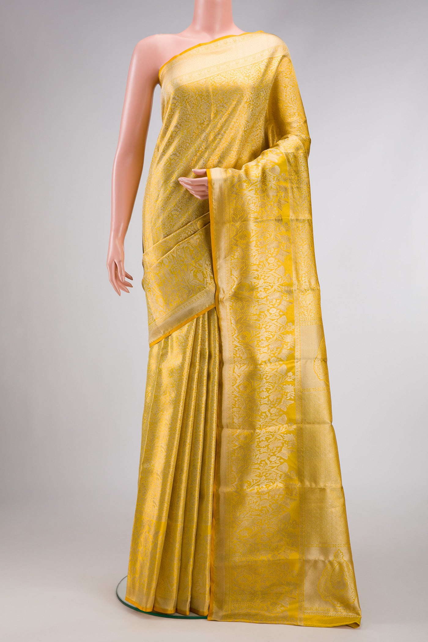Gold Dual Tone Kanjivaram Tissue Silk Saree with Zari Brocade on the body and Zari Border.  displayed on a mannequin