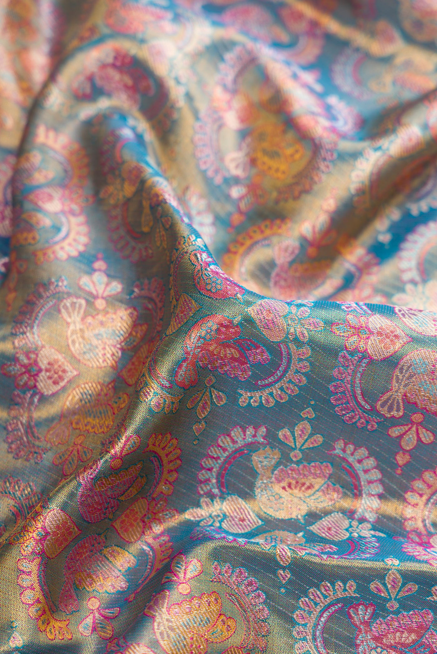 Close up of Blue Dual Tone Kanjivaram Tissue Silk Saree with Zari Brocade on the body and Zari Border.  displaying folds