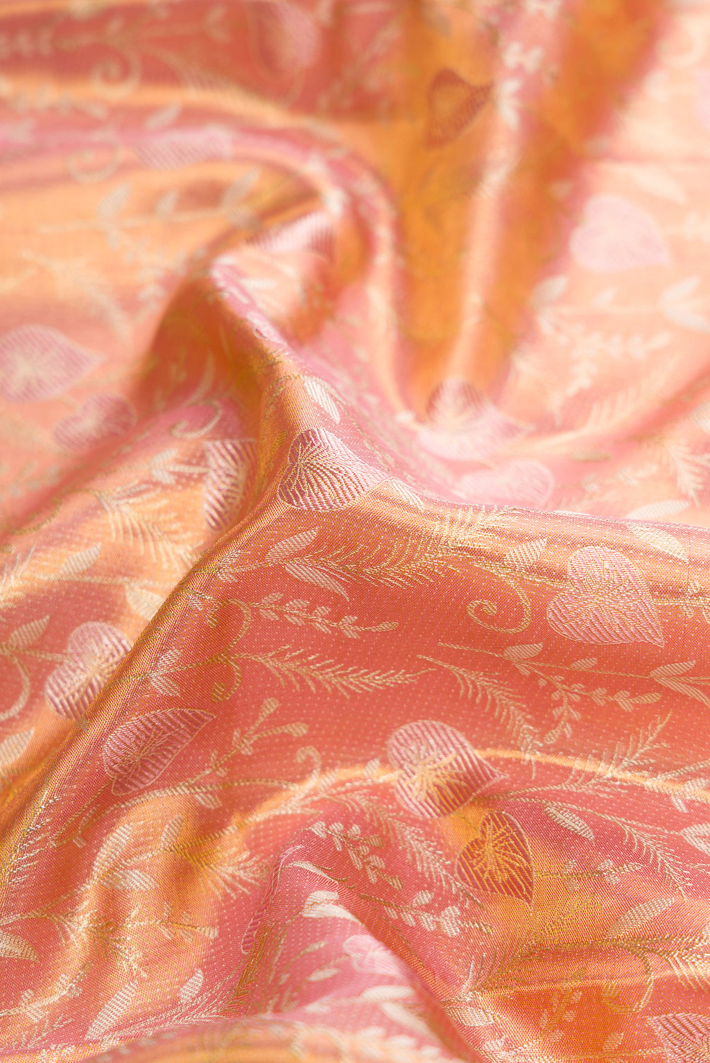 Close up of Rose Gold Dual Tone Kanjivaram Tissue Silk Saree with Zari Brocade on the body and Fancy Border.  displaying folds