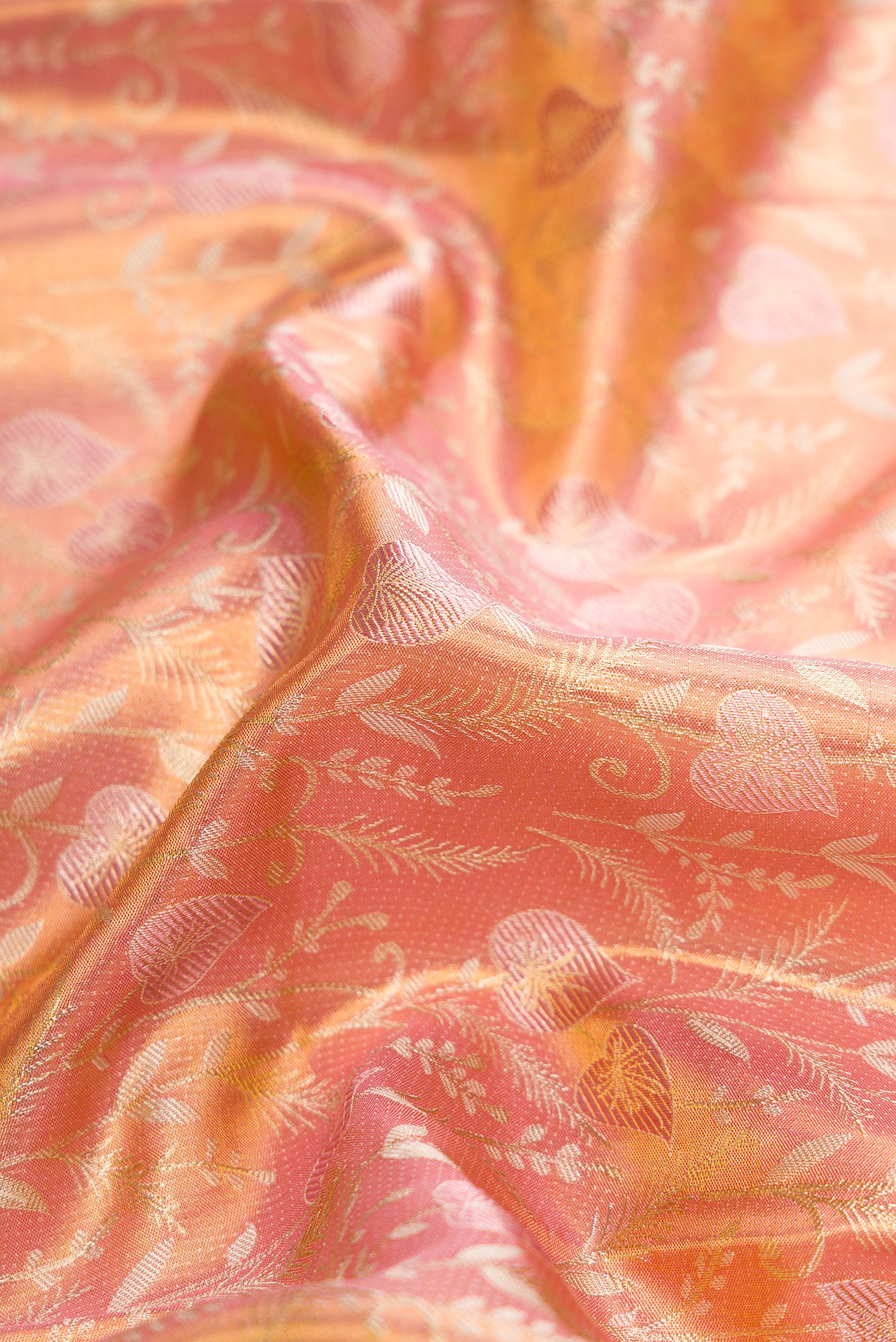 Close up of Rose Gold Dual Tone Kanjivaram Tissue Silk Saree with Zari Brocade on the body and Fancy Border.  displaying folds