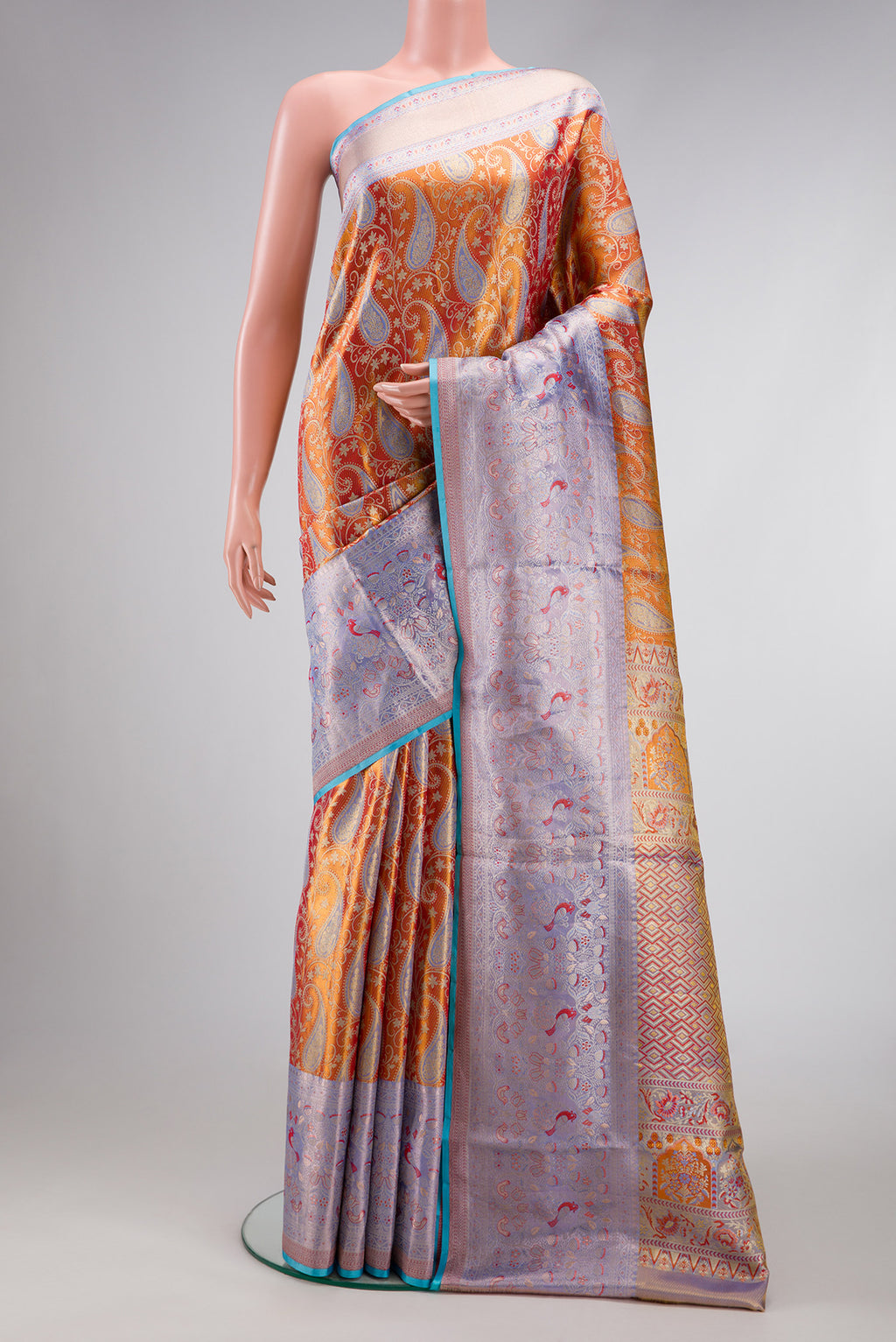 Orange Dual Tone Kanjivaram Tissue Silk Saree with Zari Brocade on the body and Fancy Border.  displayed on a mannequin