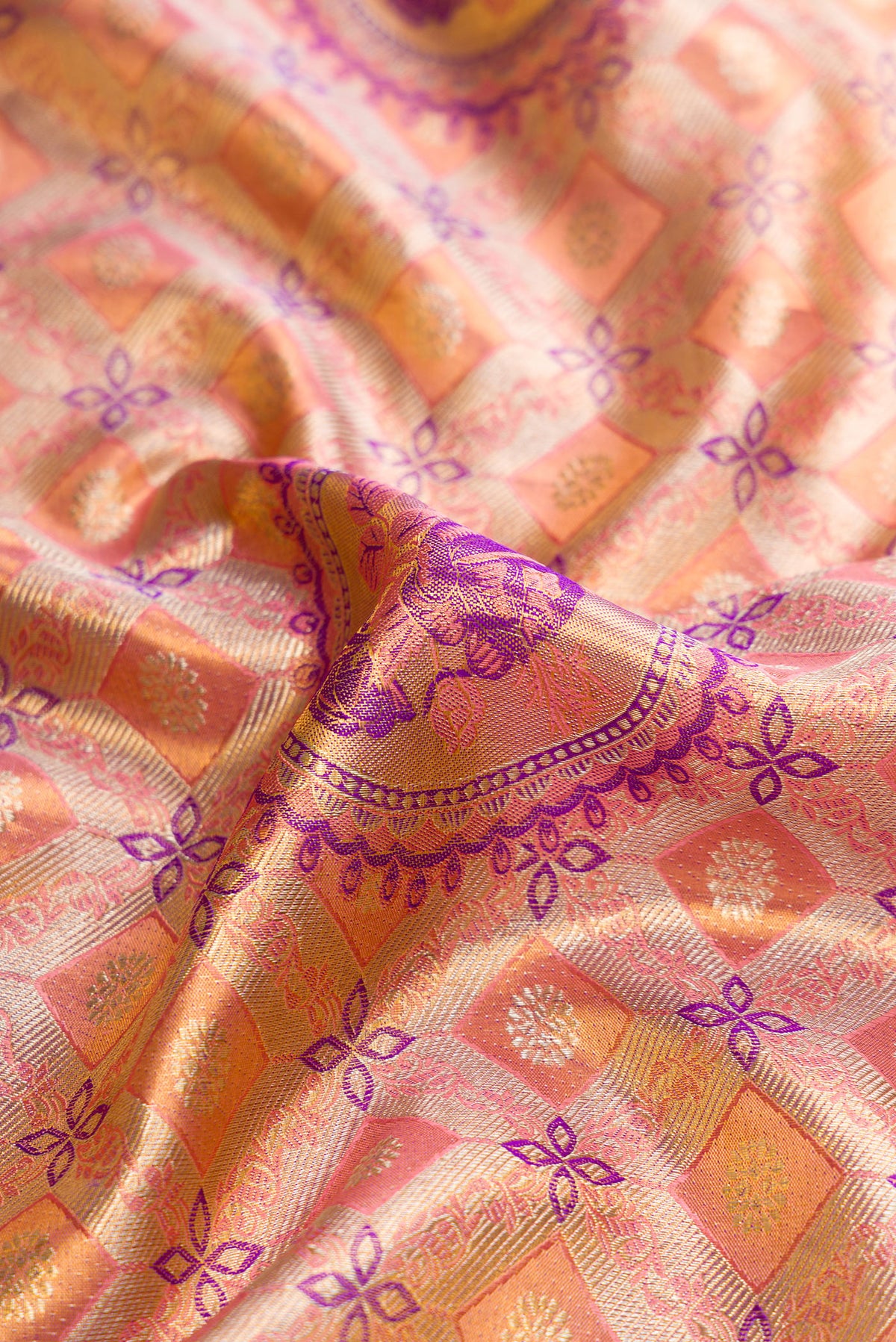 Close up of Peach Dual Tone Kanjivaram Tissue Silk Saree with Zari Brocade on the body and Fancy Border.  displaying folds