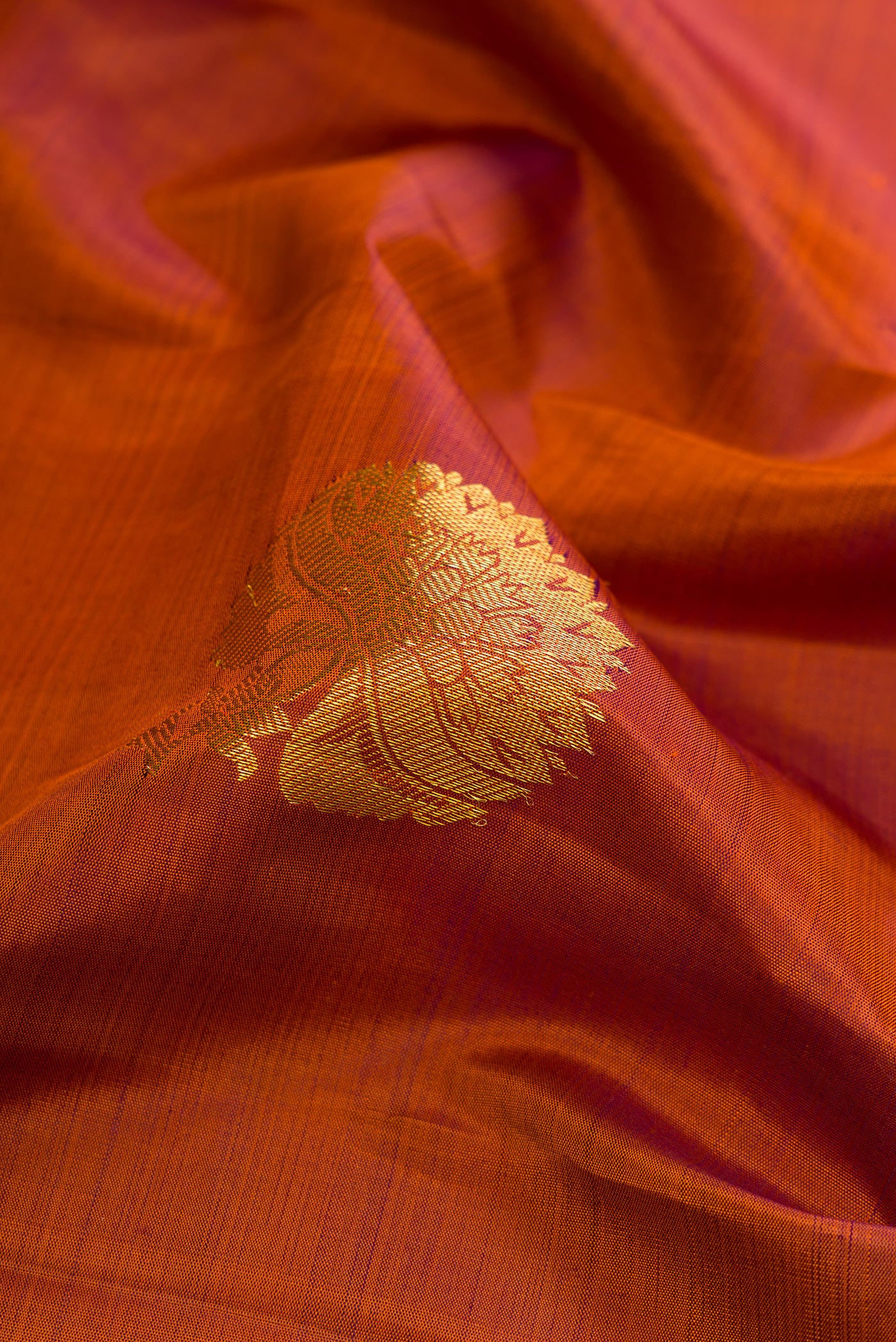Close up of Brown Dual Tone Kanjivaram Silk Saree with Zari Butta on the body and Zari Border.  displaying folds