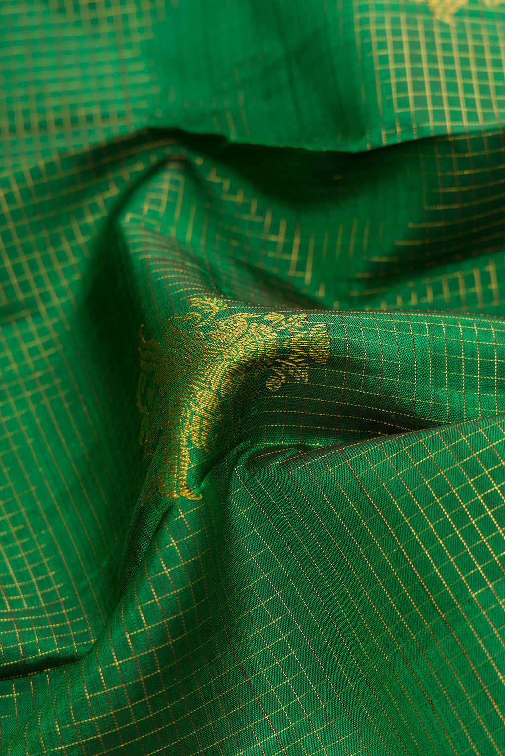 Close up of Green Dual Tone Kanchipuram Silk Saree with Stripes on the body and Zari Border.  displaying folds