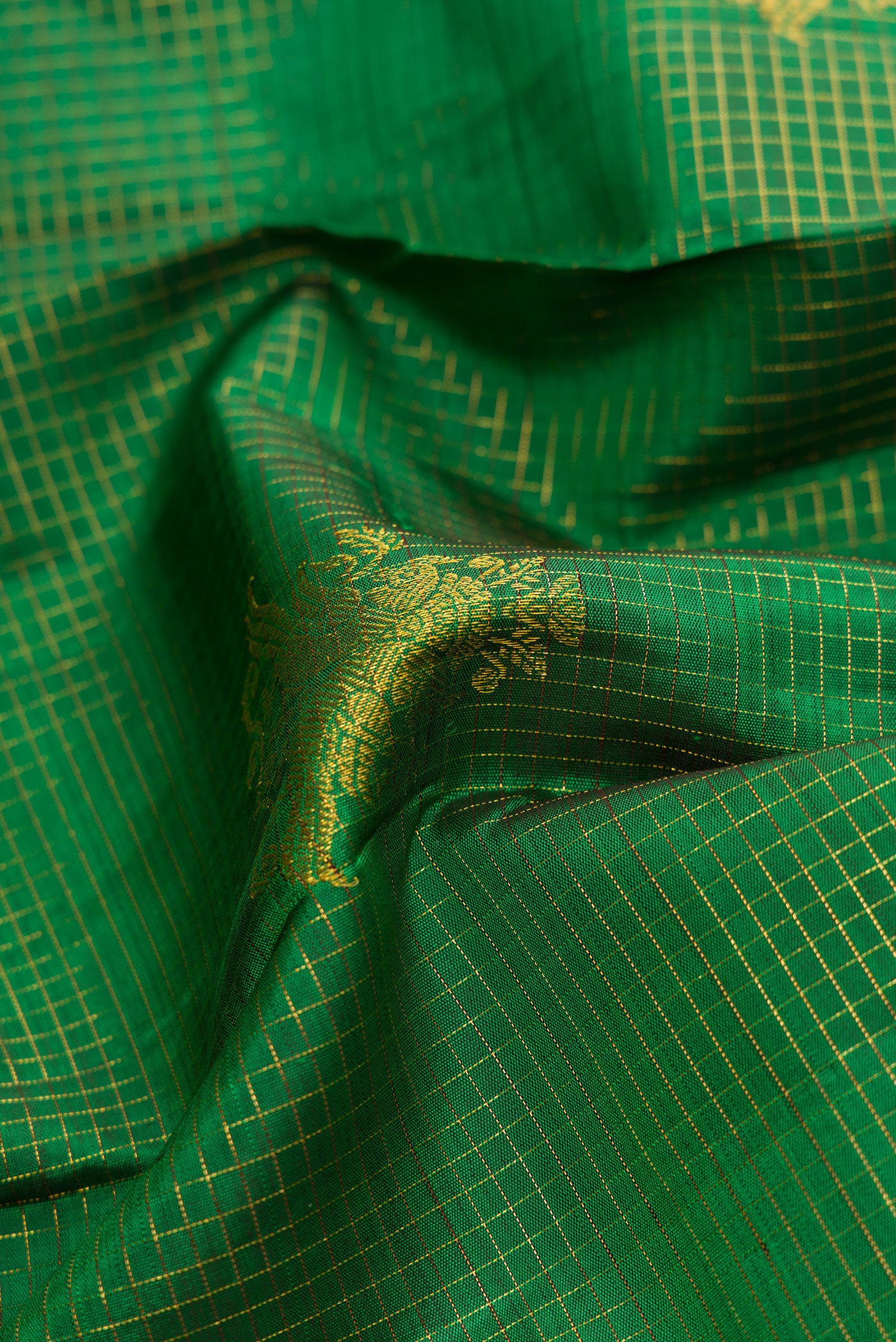 Close up of Green Dual Tone Kanchipuram Silk Saree with Stripes on the body and Zari Border.  displaying folds